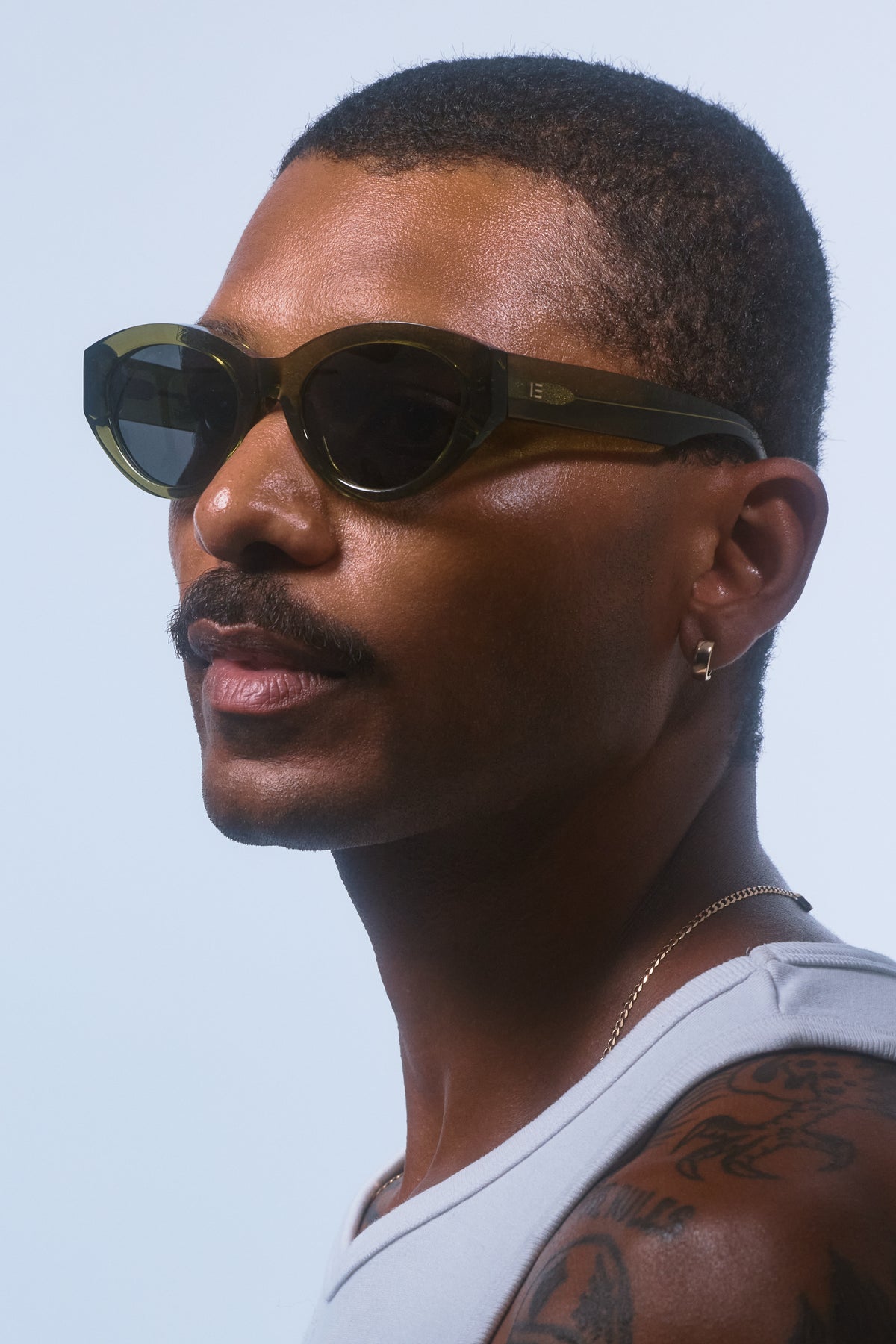 Male model wearing Isle of Eden Felina frosted green sunglasses, side profile portrait