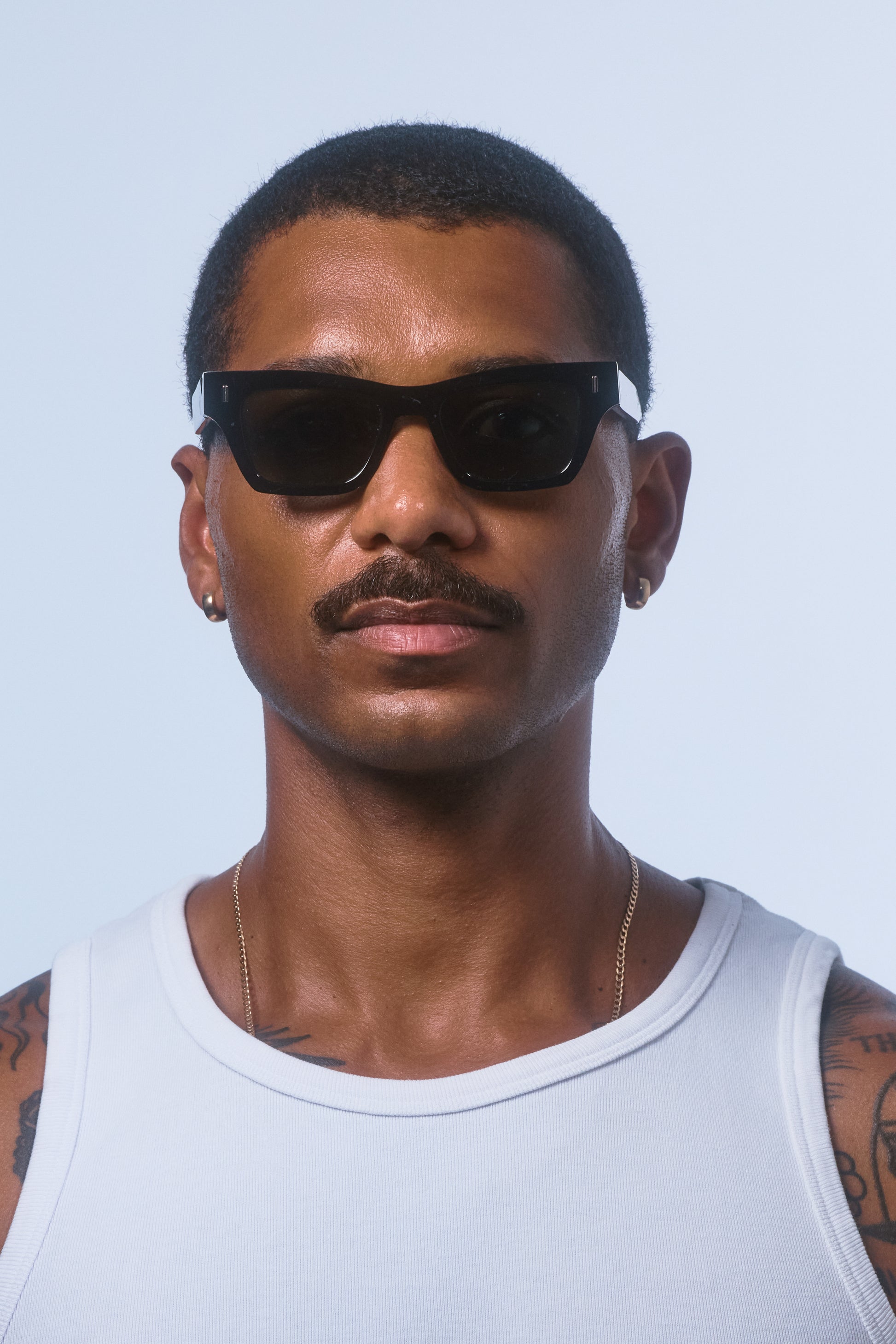 Male model wearing Isle of Eden Olli black sunglasses, front-facing portrait looking directly at the camera