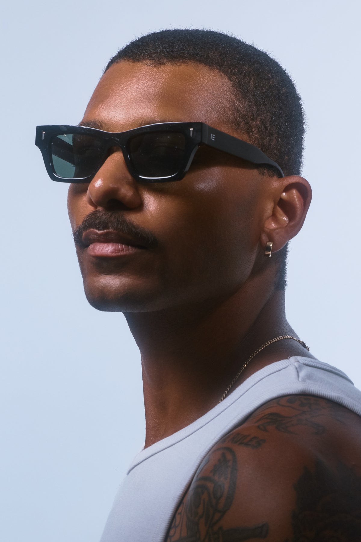 Male model wearing Isle of Eden Olli black sunglasses, angled portrait looking away