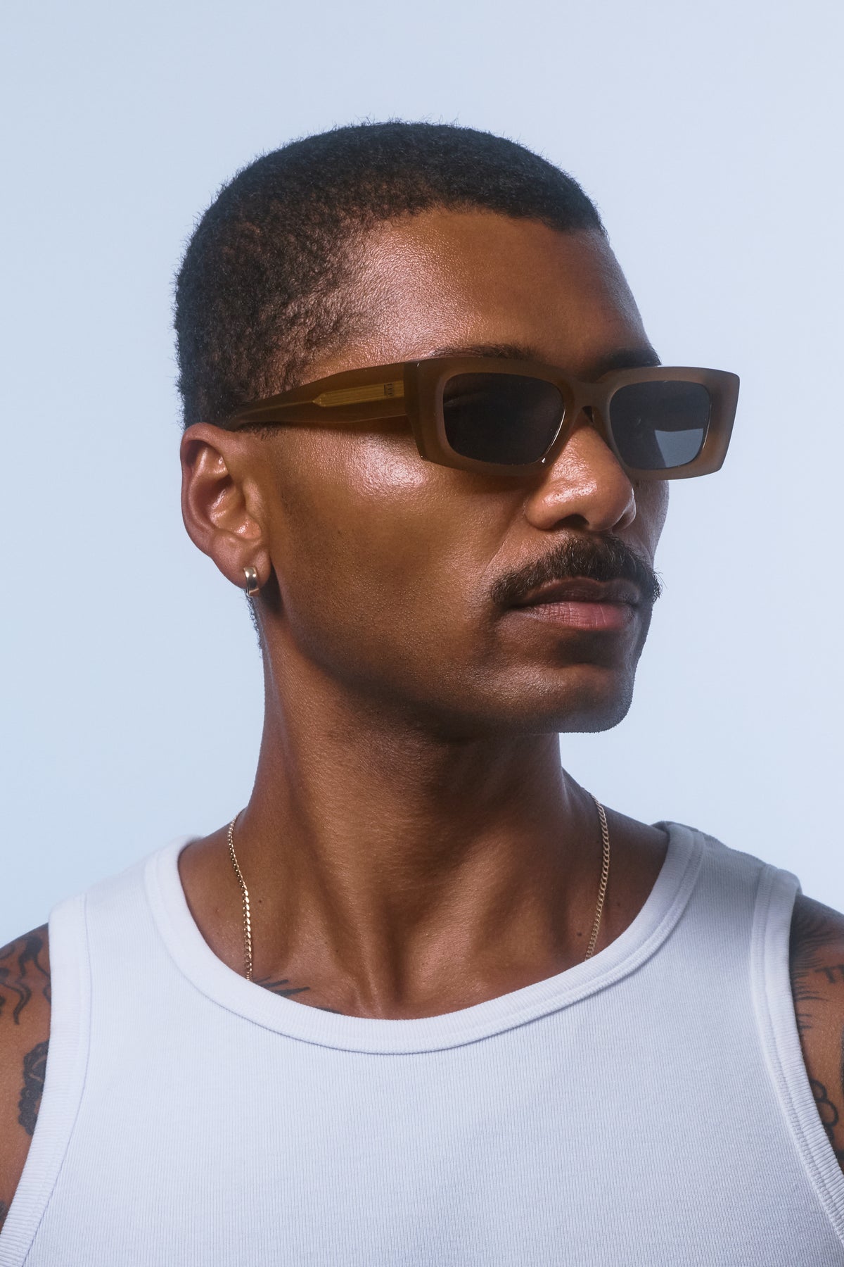 Male model wearing Isle of Eden Goldie dijon sunglasses, angled portrait