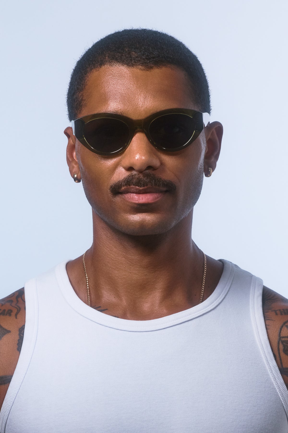 Male model wearing Isle of Eden Felina frosted green sunglasses, front-facing portrait looking directly at the camera