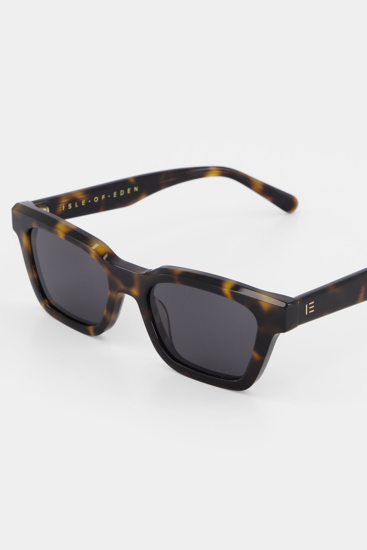 Close-up of Isle of Eden Brooklyn tortoise sunglasses showing brand lettering on temple arm