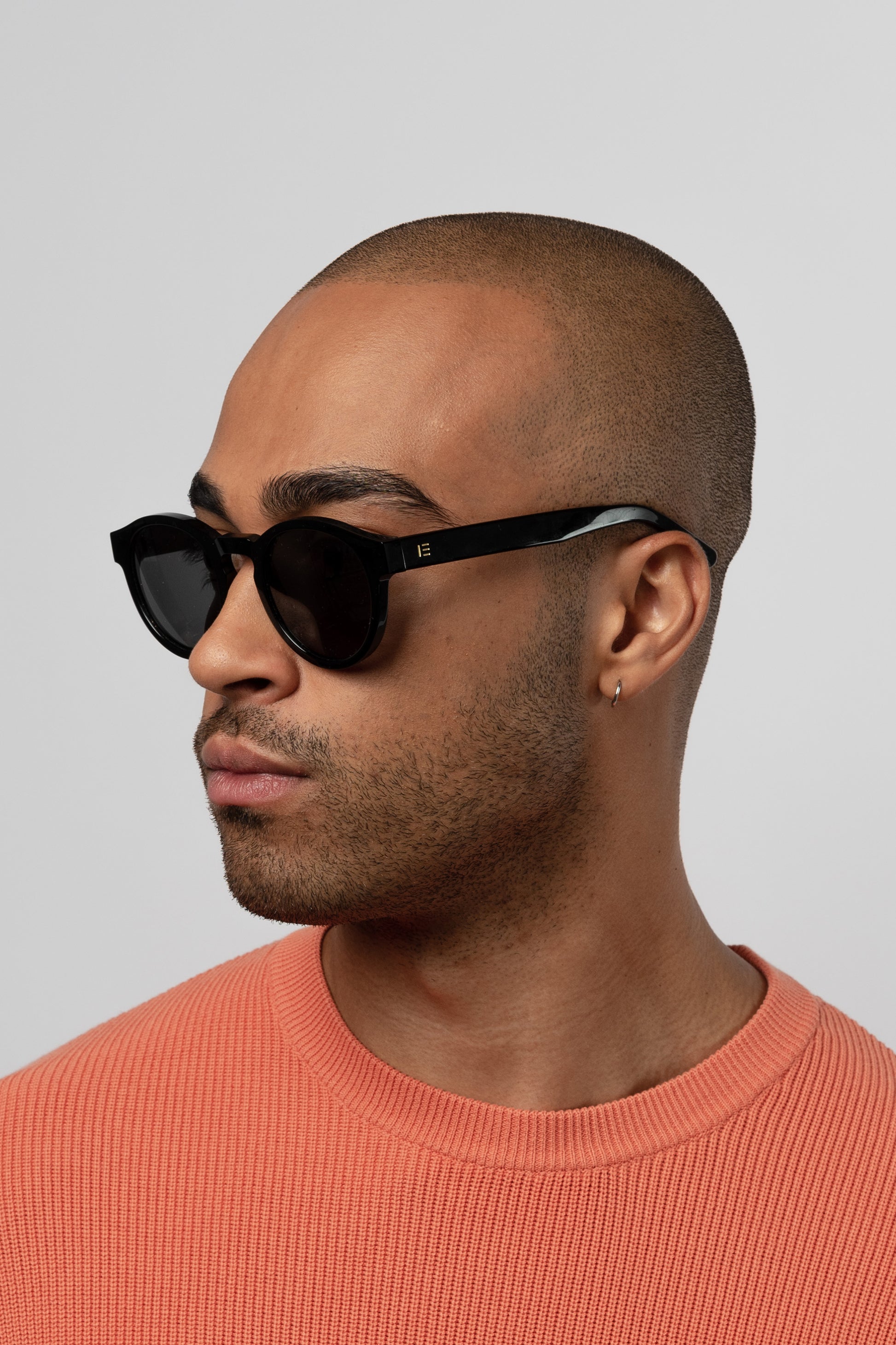 Male model wearing Isle of Eden Eddie black sunglasses, side profile portrait