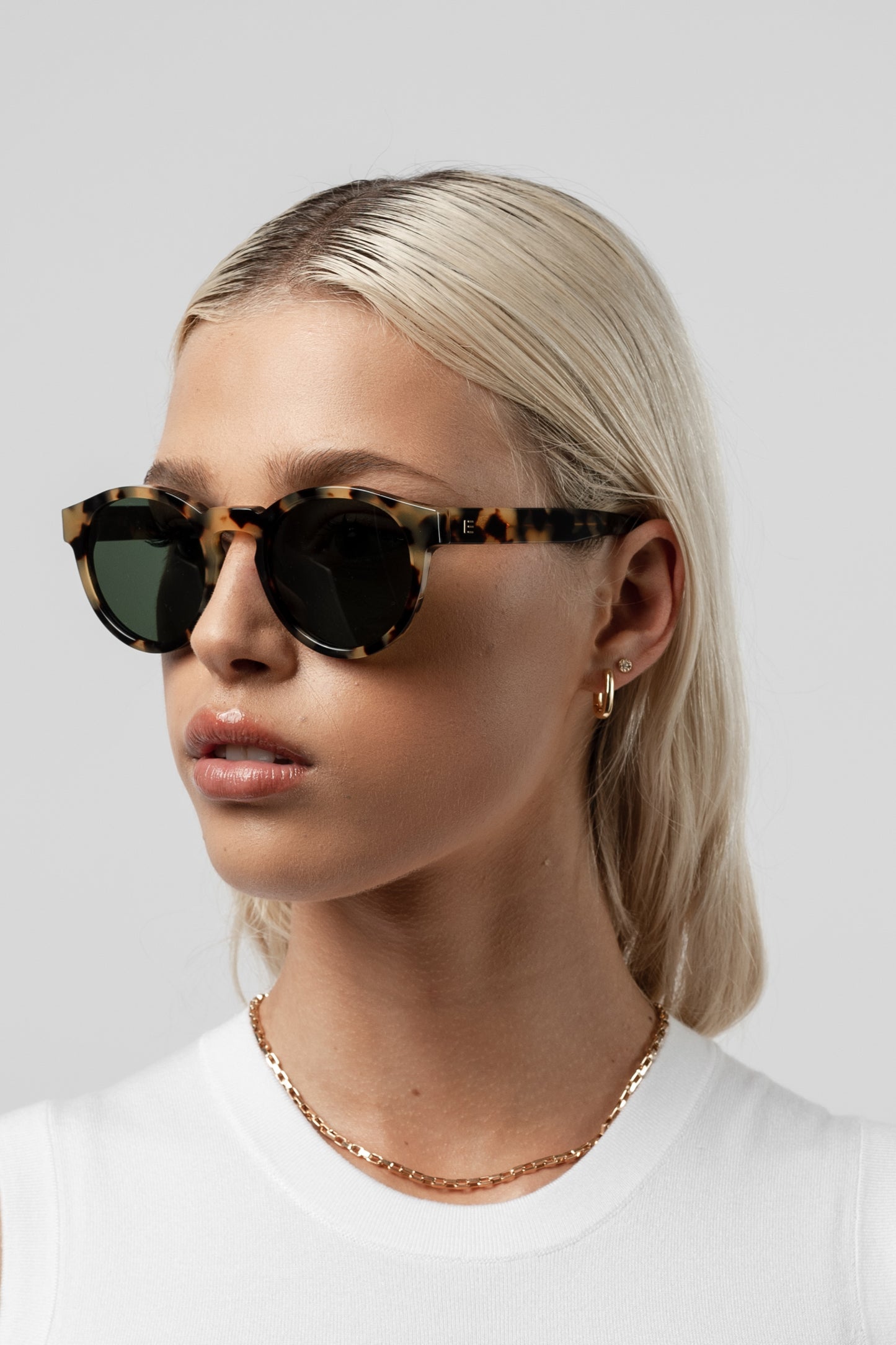 Female model wearing Isle of Eden Eddie tortoise sunglasses, angled portrait
