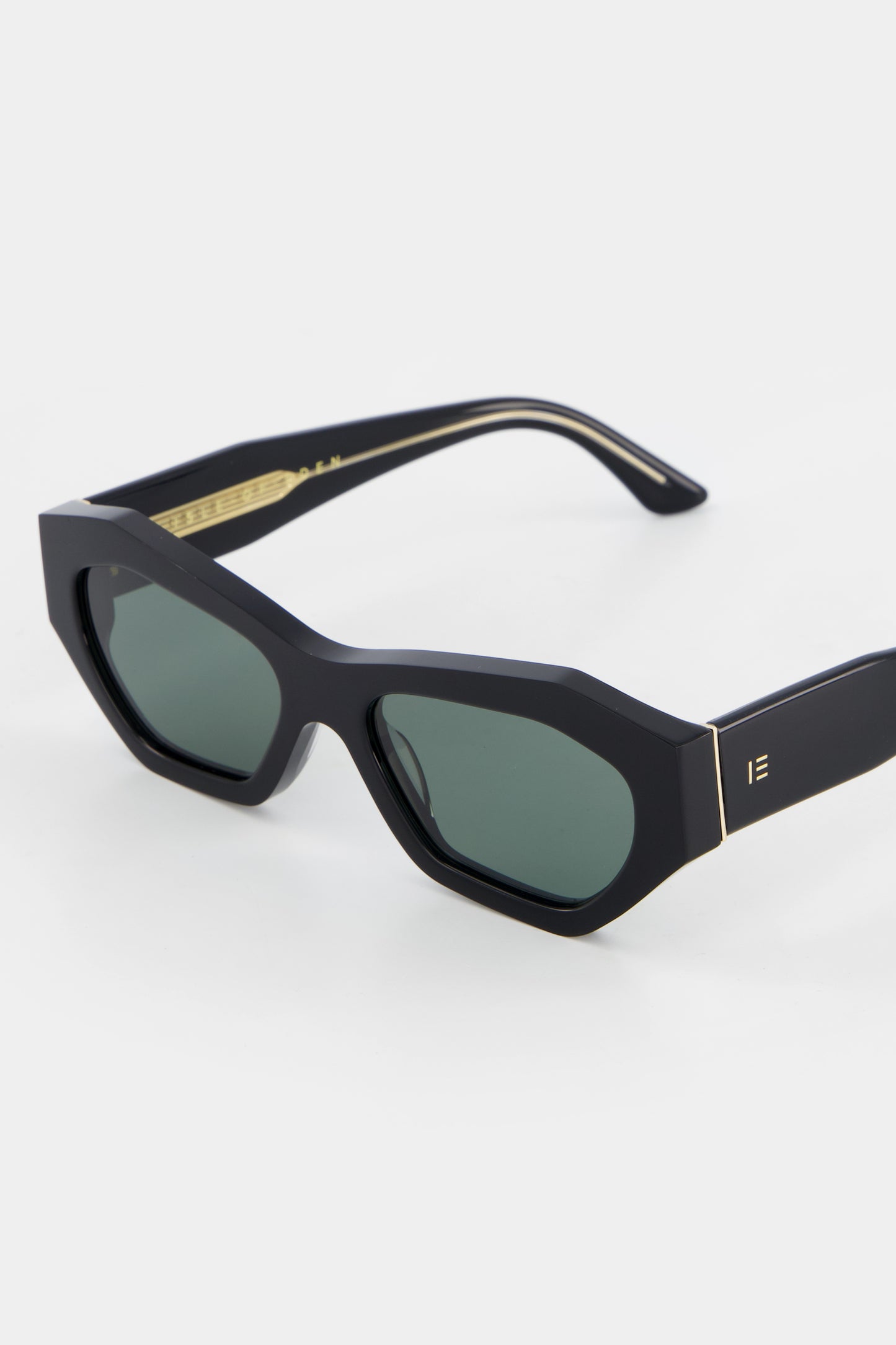 Close-up of Isle of Eden Emily black sunglasses showing angular frame and brand lettering