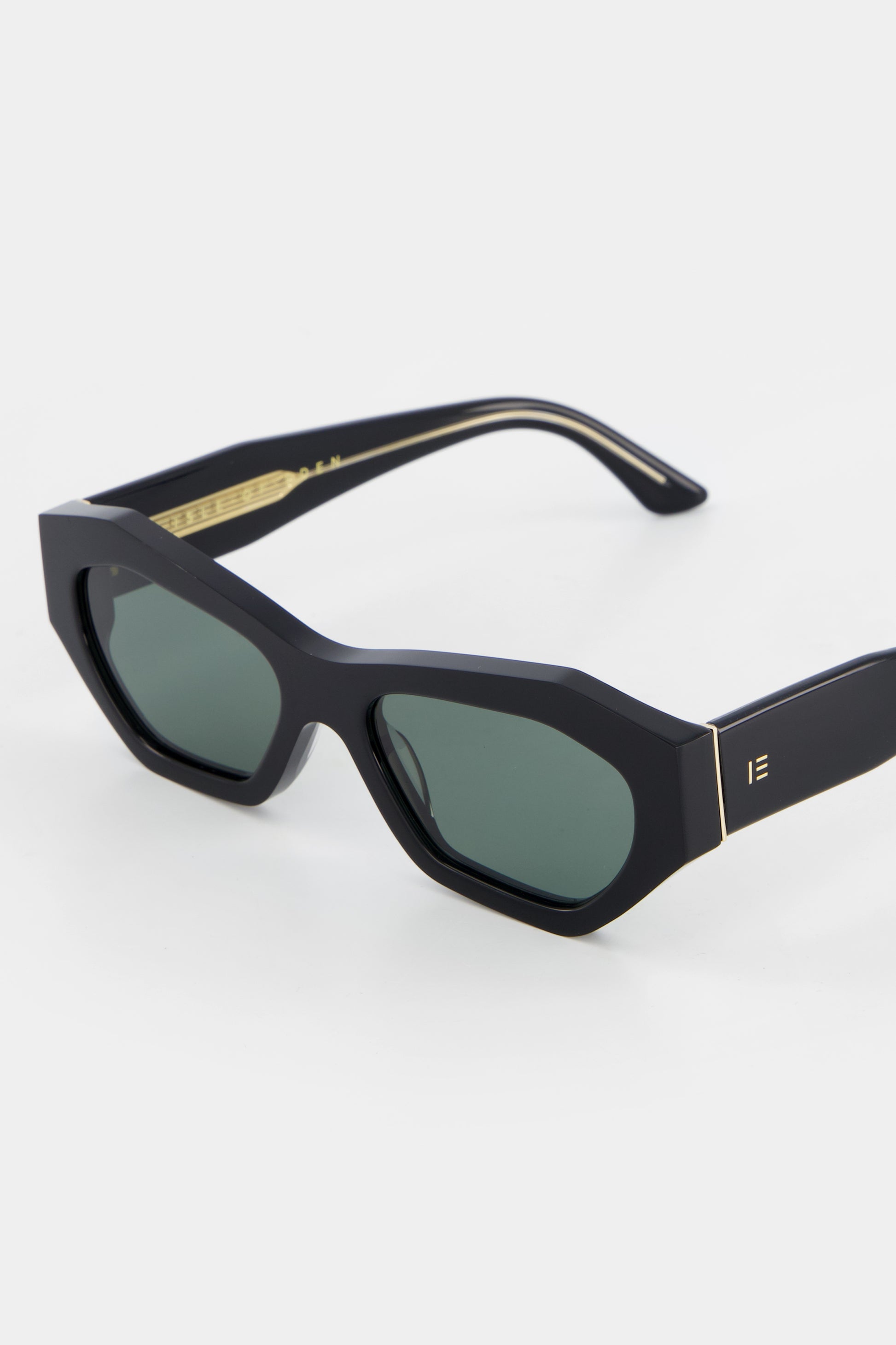 Close-up of Isle of Eden Emily black sunglasses showing angular frame and brand lettering