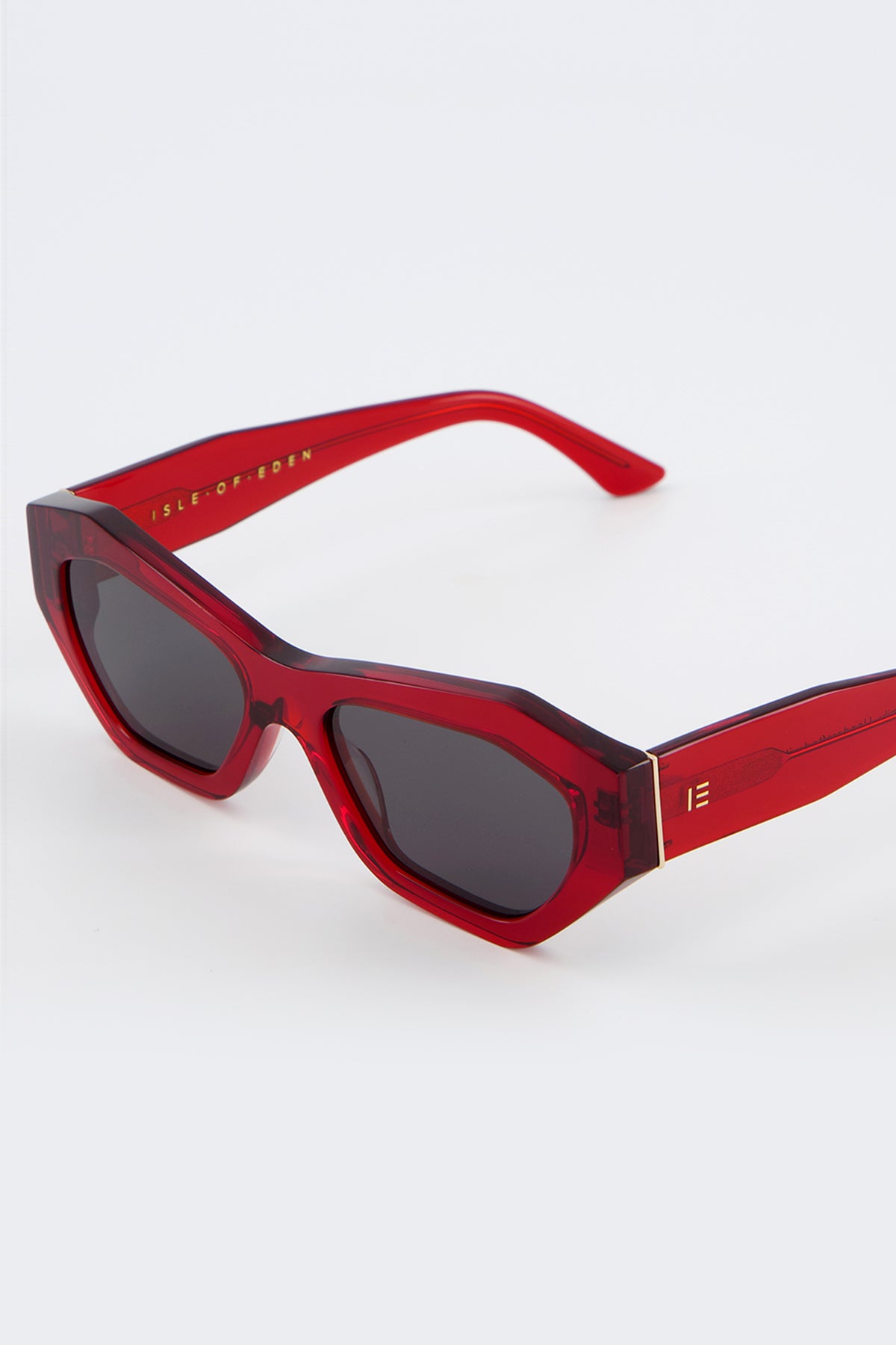 Close-up of Isle of Eden Emily red sunglasses showing angular frame and brand lettering