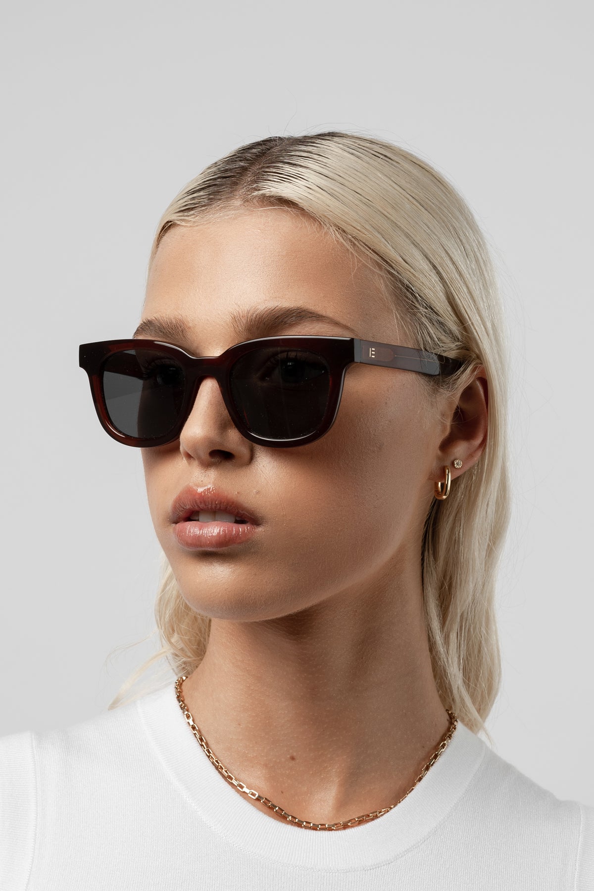 Female model wearing Isle of Eden Eugene brown sunglasses, front-facing portrait looking directly at the camera