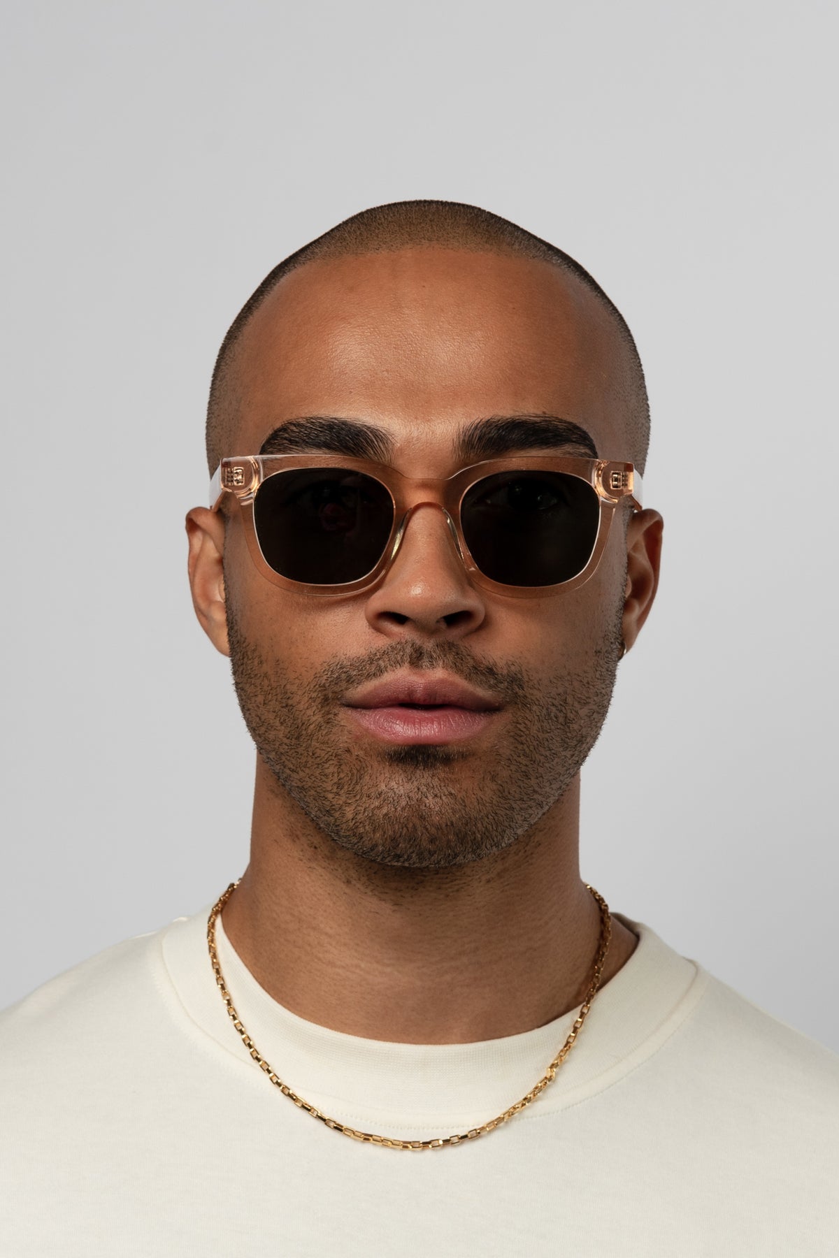 Male model wearing Isle of Eden Eugene champagne sunglasses, front-facing portrait looking directly at the camera