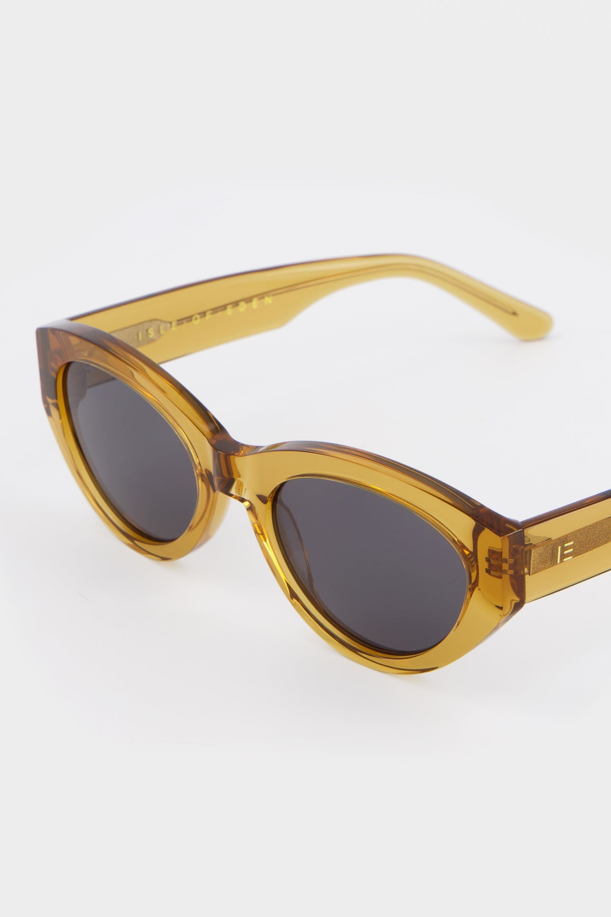 Close-up of Isle of Eden Felina cognac sunglasses showing cat-eye frame and brand lettering