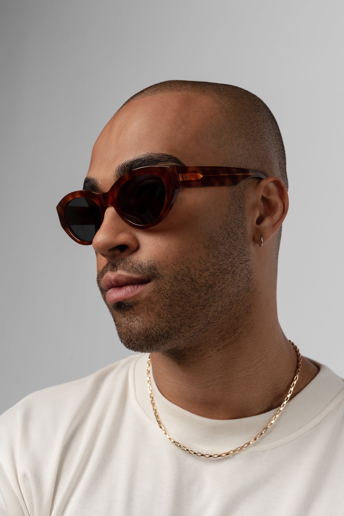 Male model wearing Isle of Eden Felina whisky tortoise sunglasses, angled portrait