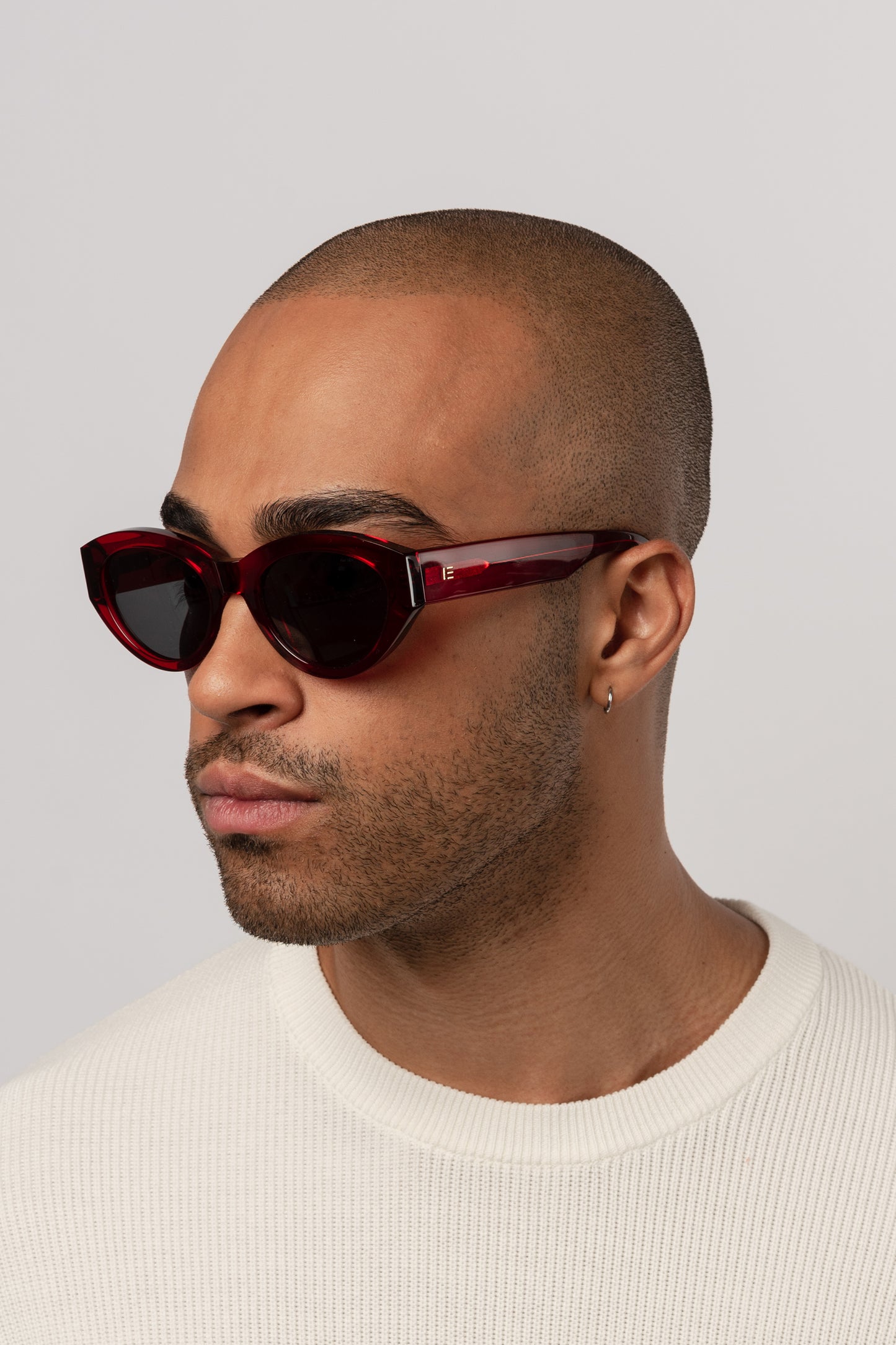 Male model wearing Isle of Eden Felina red sunglasses, angled portrait