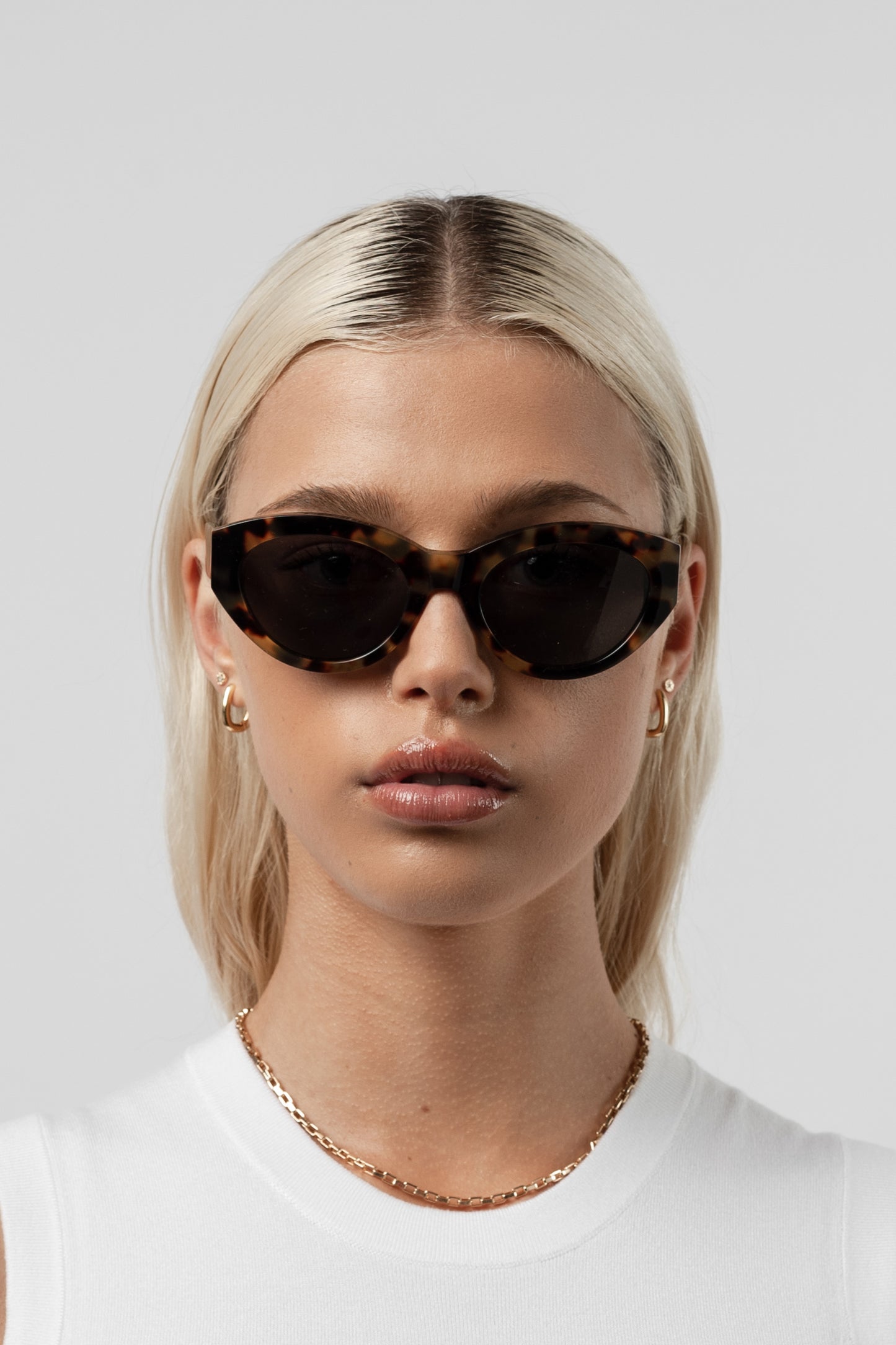 Female model wearing Isle of Eden Felina tortoise sunglasses, front-facing portrait looking directly at the camera