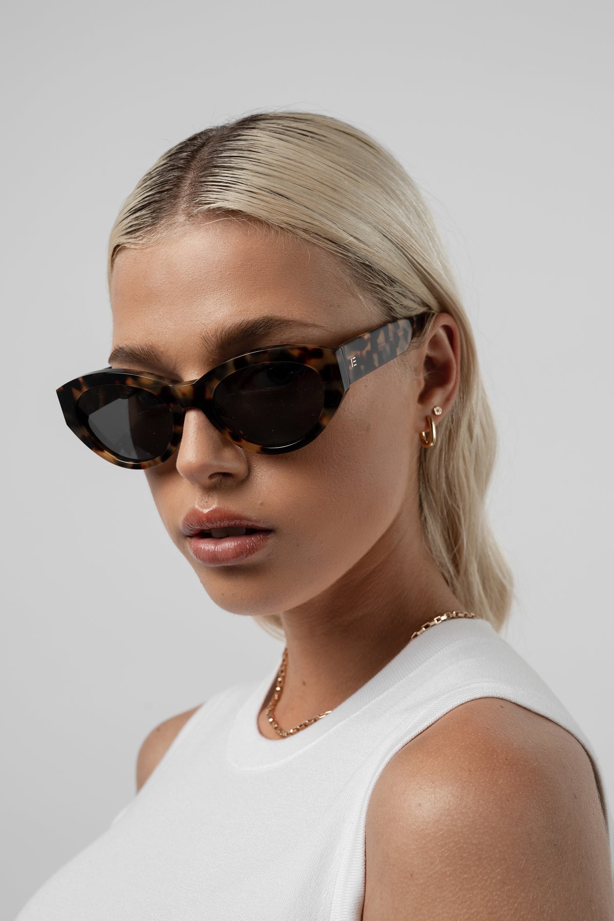 Female model wearing Isle of Eden Felina tortoise sunglasses, angled portrait looking away