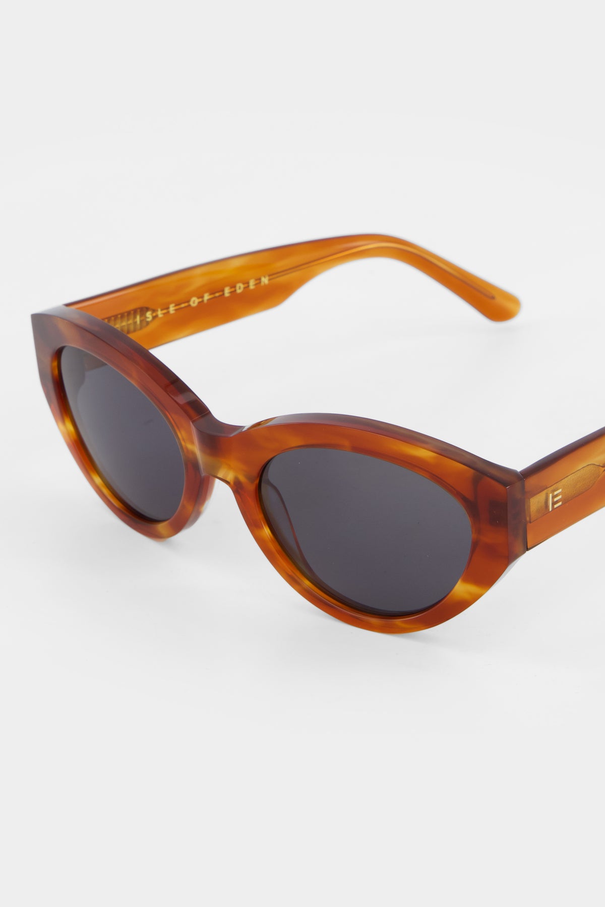 Close-up of Isle of Eden Felina whisky tortoise sunglasses showing cat-eye frame and brand lettering