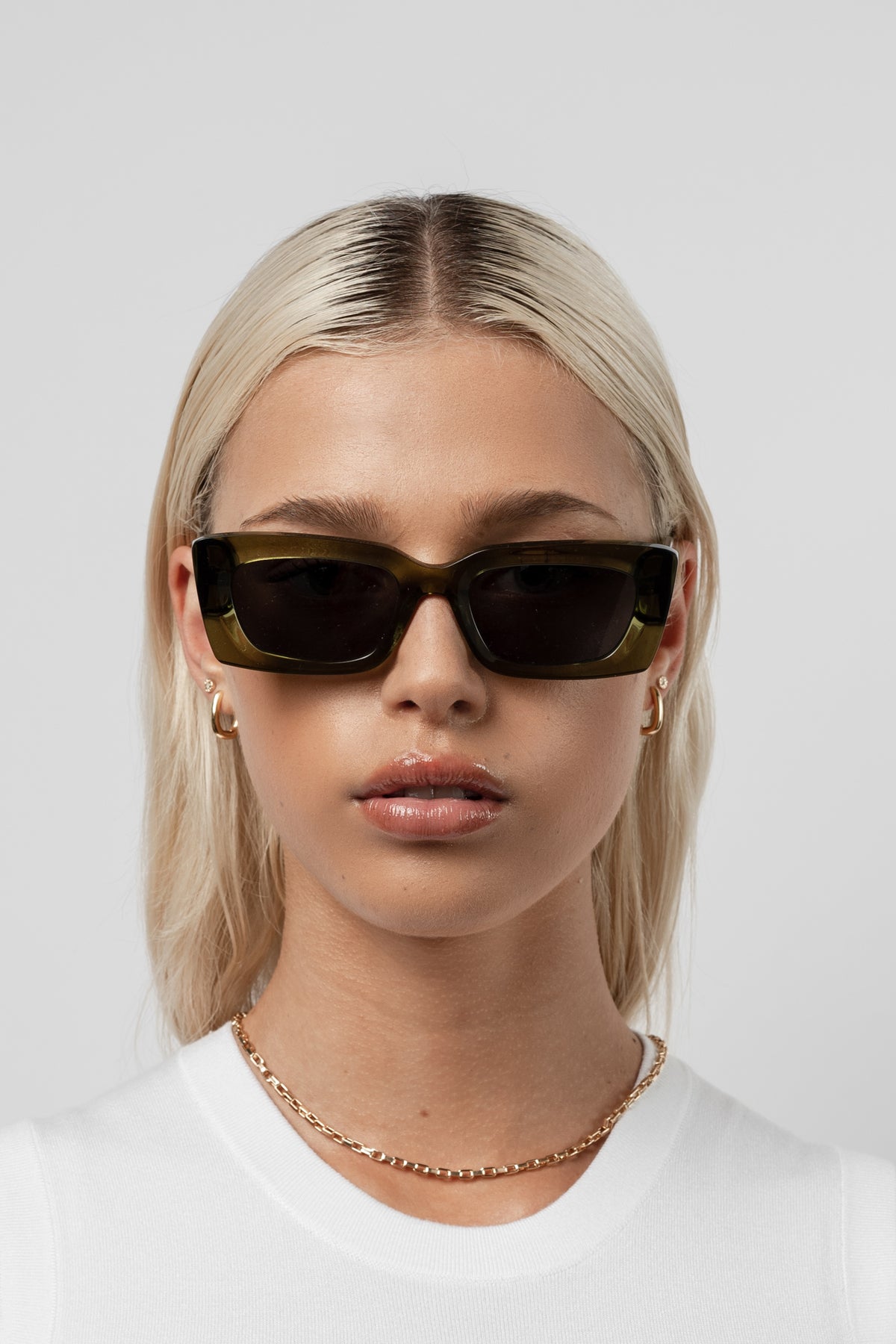 Female model wearing Isle of Eden Goldie green sunglasses, front-facing portrait