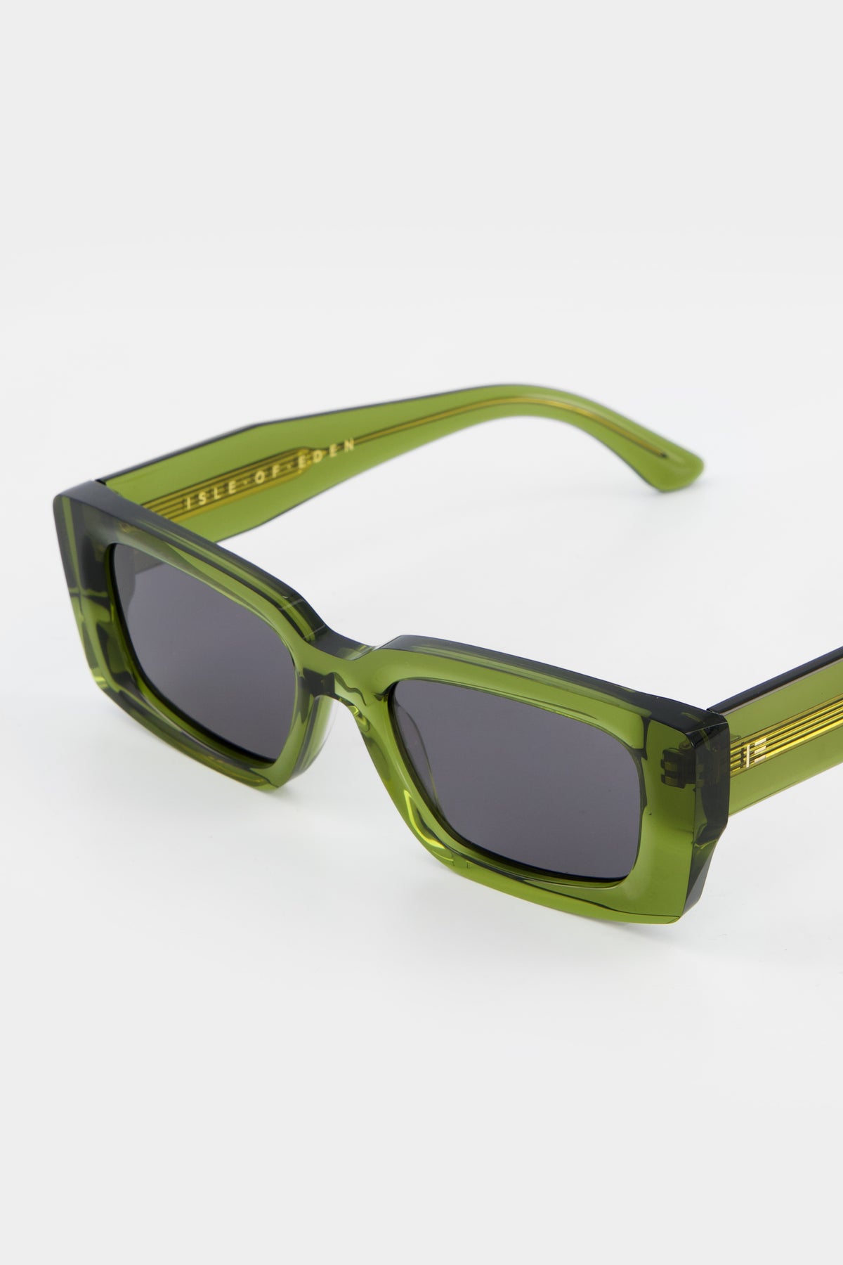 Close-up of Isle of Eden Goldie green sunglasses showing rectangular frame and brand lettering