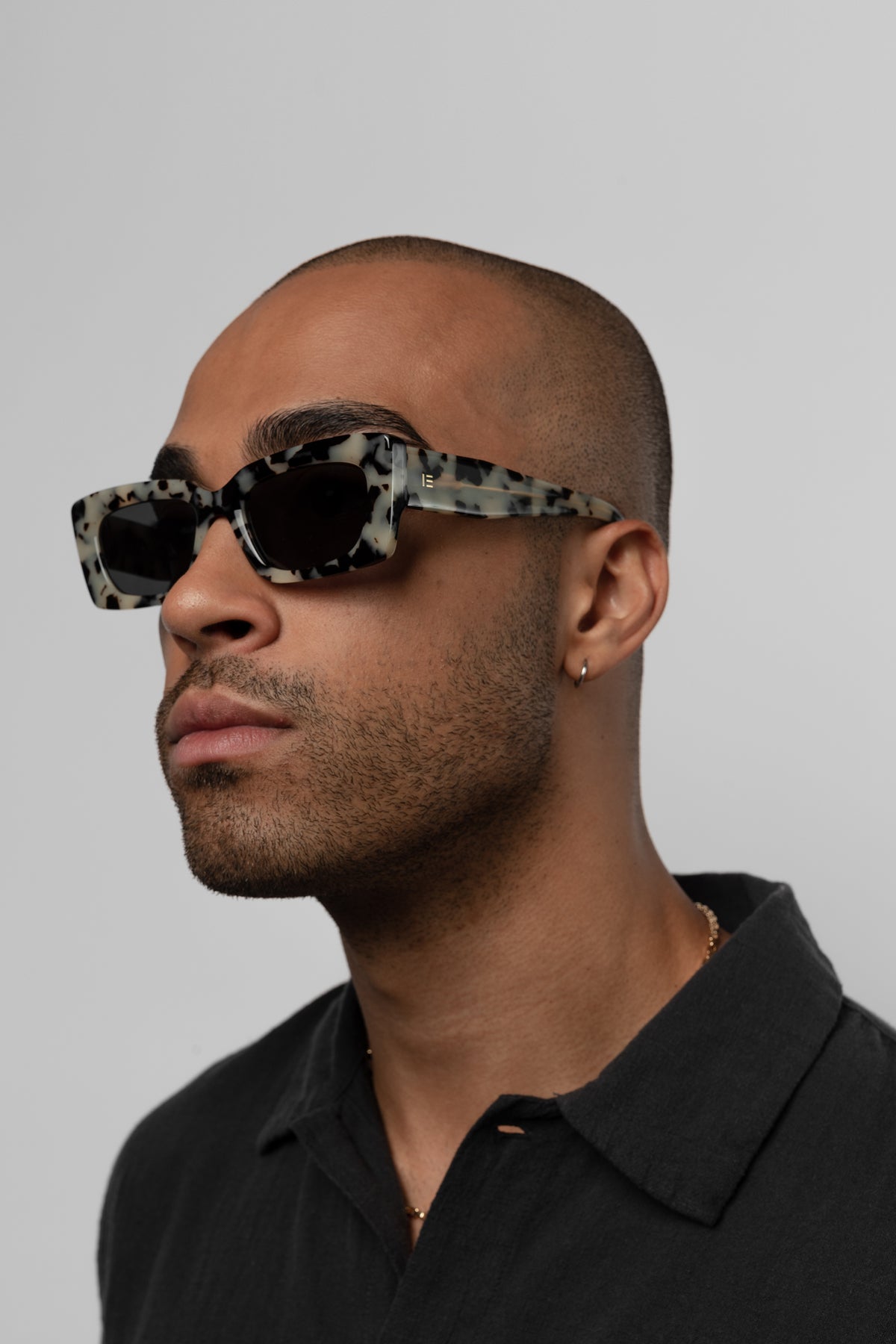 Male model wearing Isle of Eden Goldie white tortoise sunglasses, angled portrait
