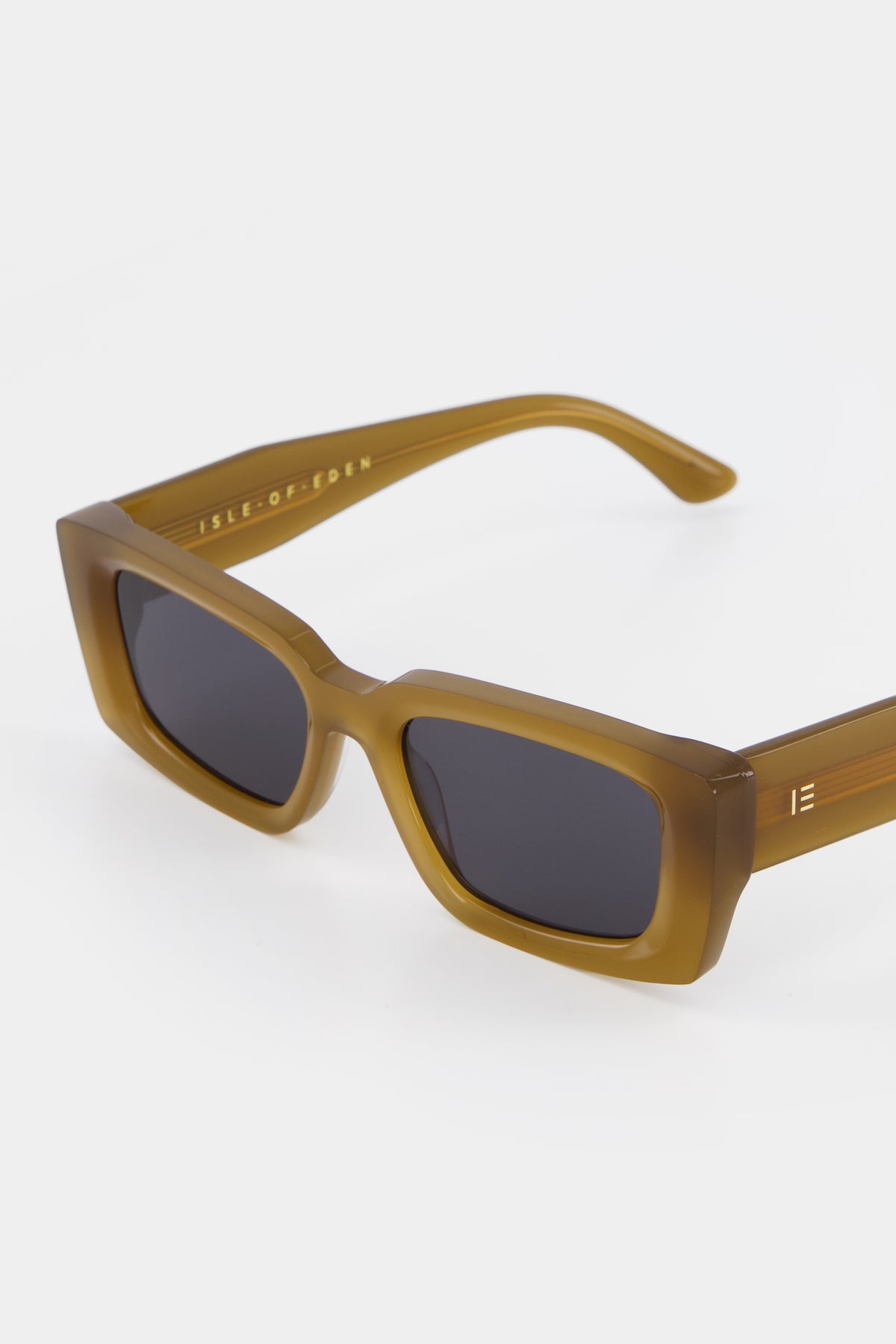 Close-up of Isle of Eden Goldie dijon sunglasses showing rectangular frame and brand lettering