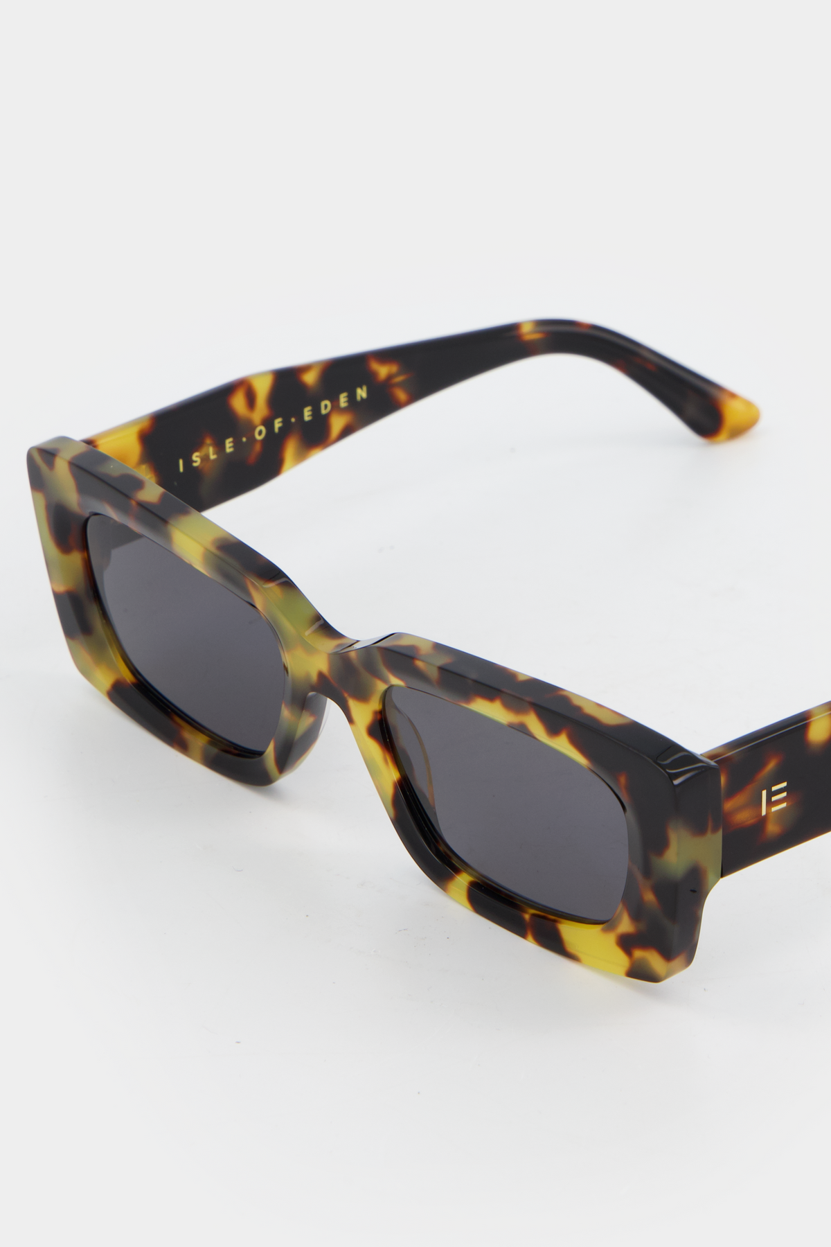 Close-up of Isle of Eden Goldie tortoise sunglasses showing rectangular frame and brand lettering