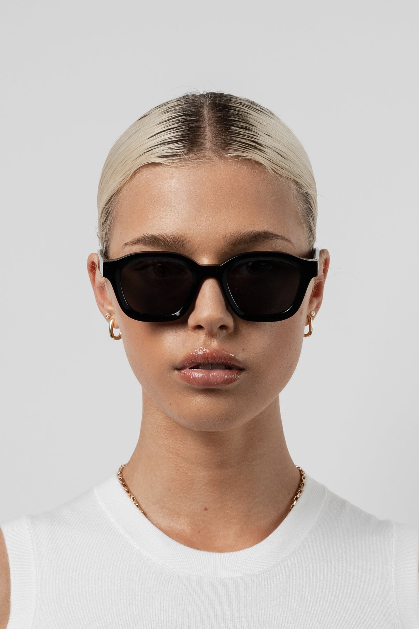 Female model wearing Isle of Eden Harley black sunglasses, front-facing portrait