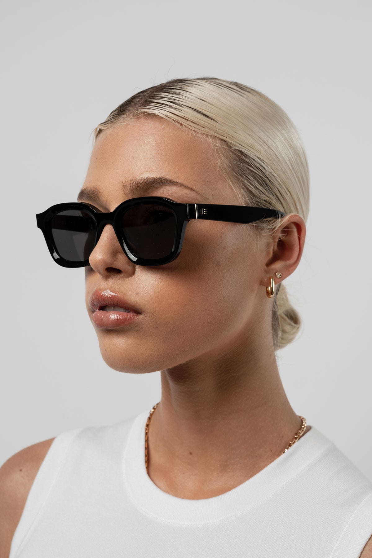 Female model wearing Isle of Eden Harley black sunglasses, side profile portrait