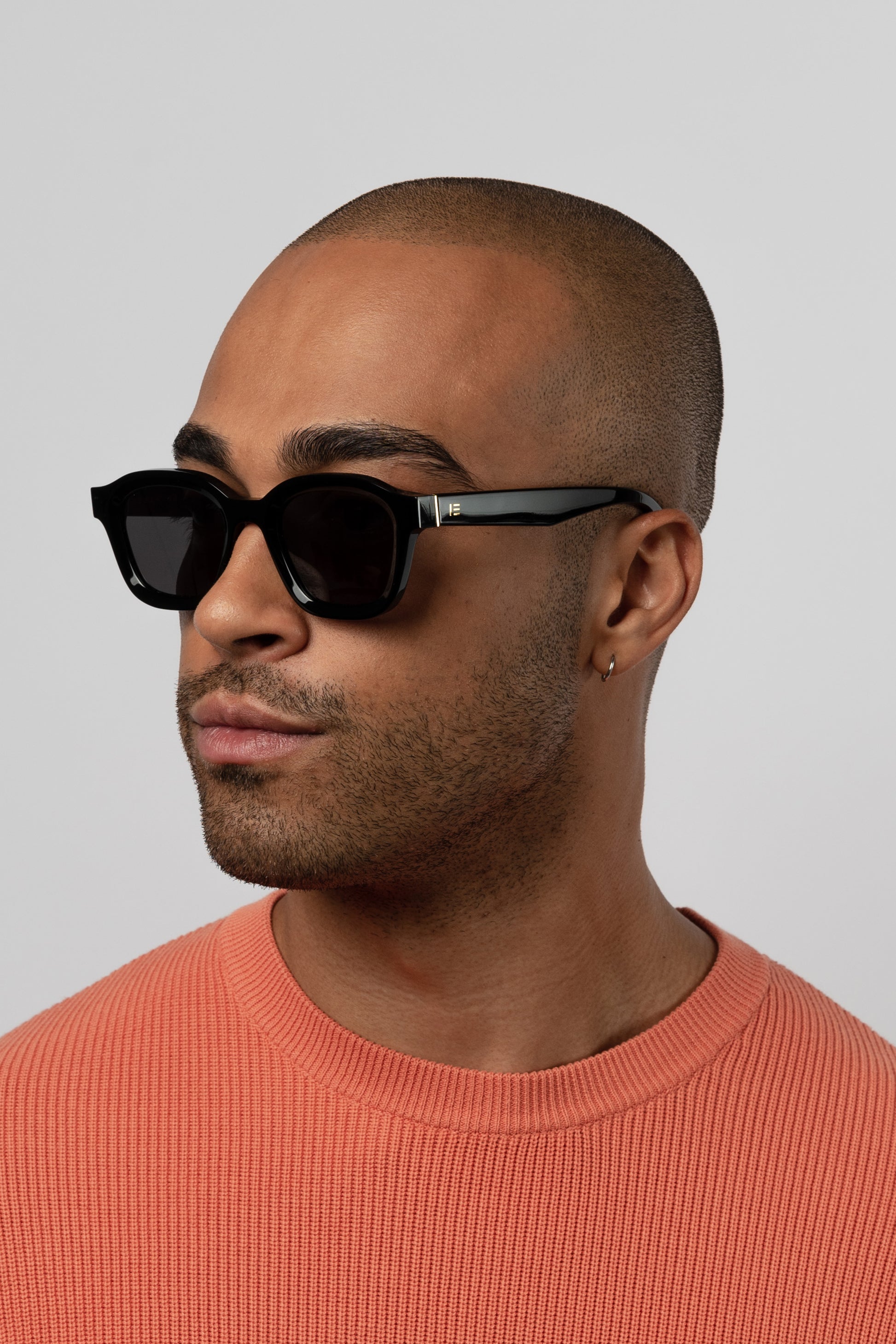 Male model wearing Isle of Eden Harley black sunglasses, angled portrait