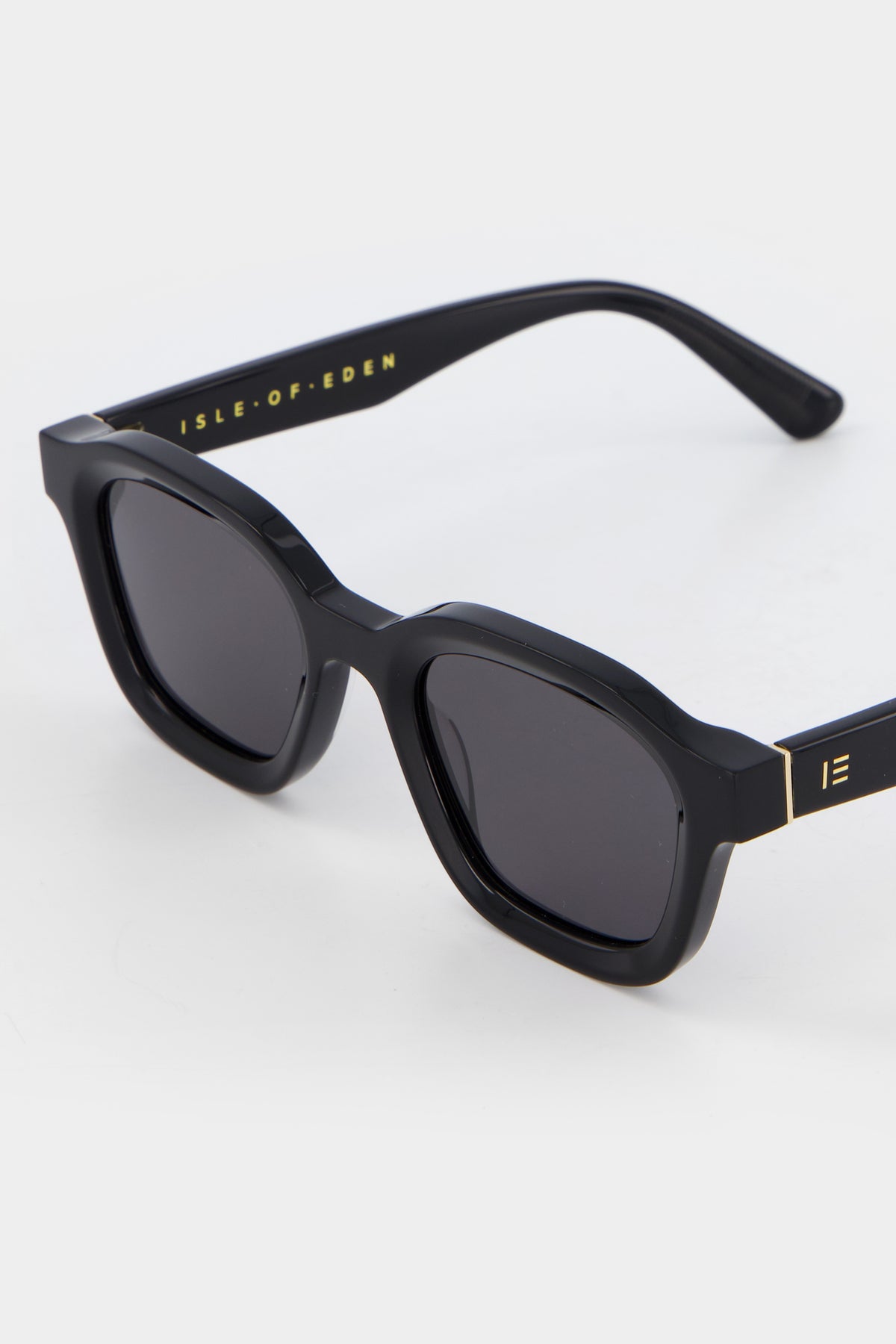 Close-up of Isle of Eden Harley black sunglasses showing bold frame and brand lettering