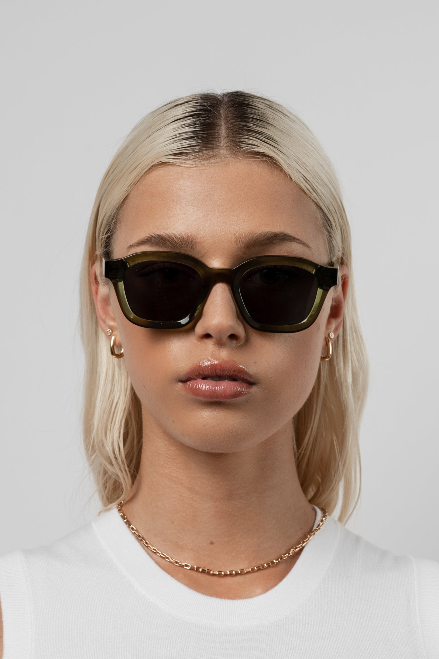 Female model wearing Isle of Eden Harley bottle green sunglasses, front-facing portrait looking directly at the camera