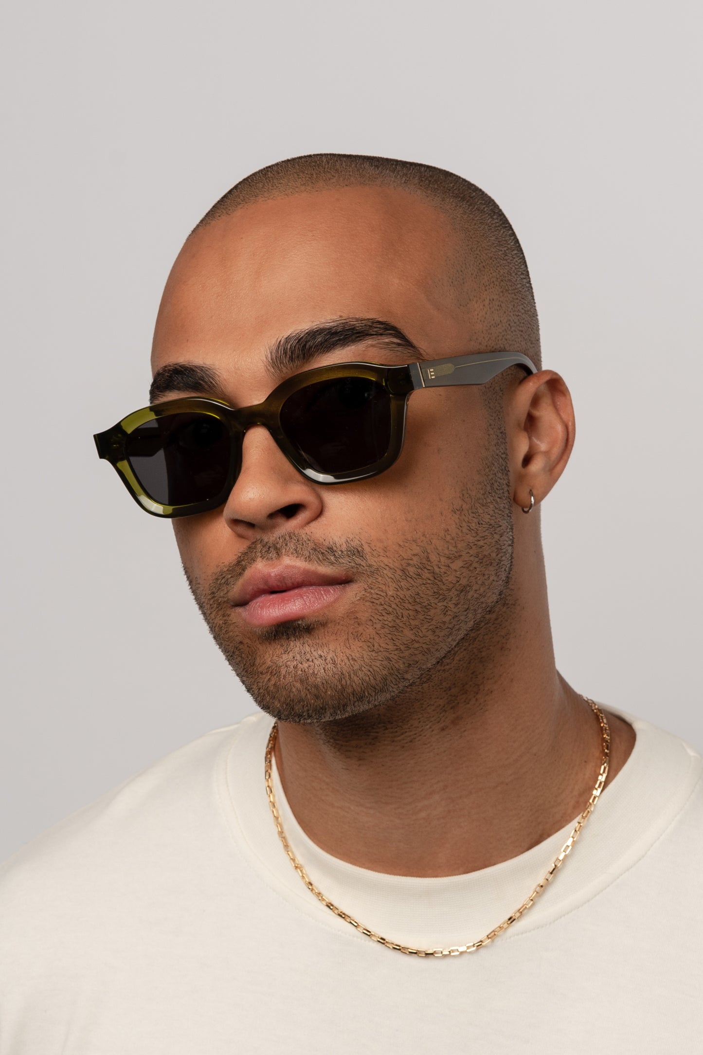 Male model wearing Isle of Eden Harley bottle green sunglasses, angled portrait
