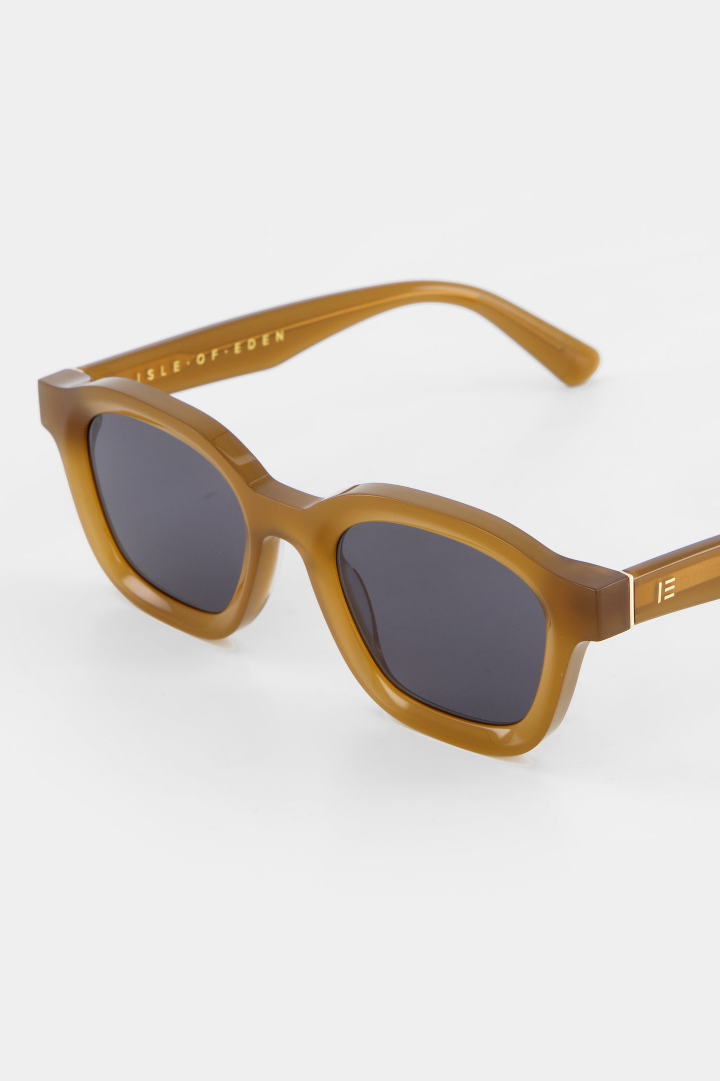 Close-up of Isle of Eden Harley dijon sunglasses showing bold frame and brand lettering