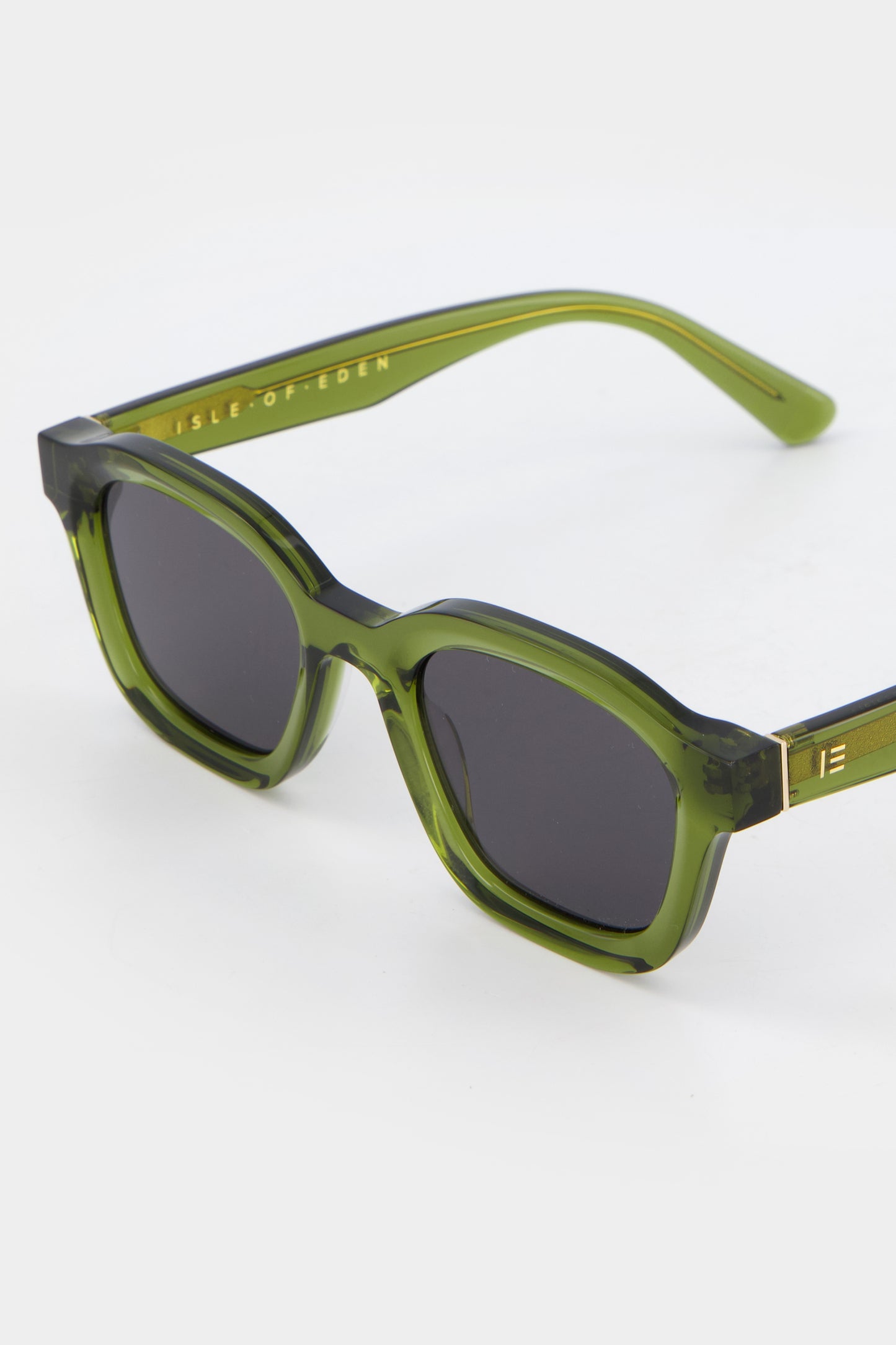 Close-up of Isle of Eden Harley bottle green sunglasses showing bold frame and brand lettering