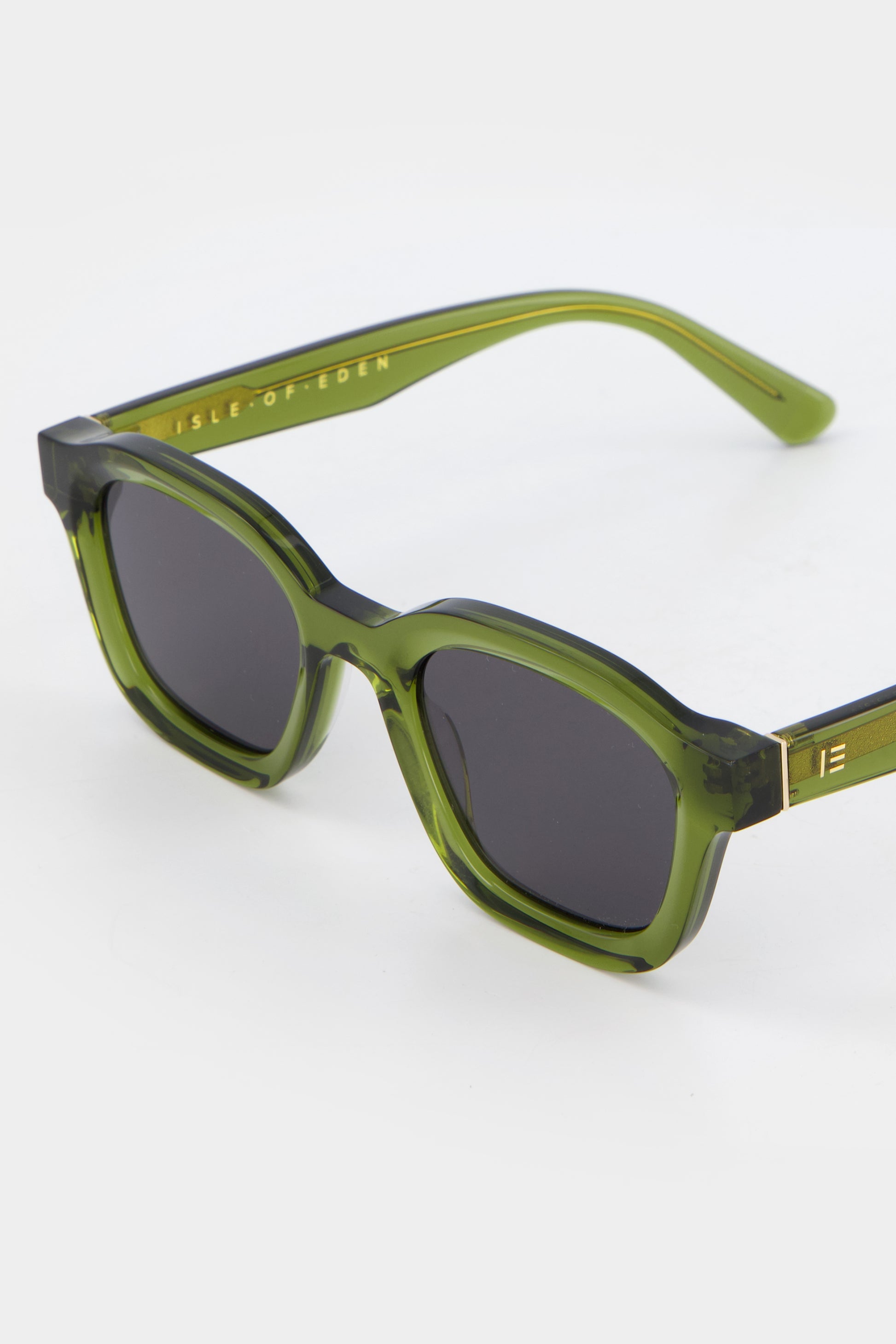 Close-up of Isle of Eden Harley bottle green sunglasses showing bold frame and brand lettering