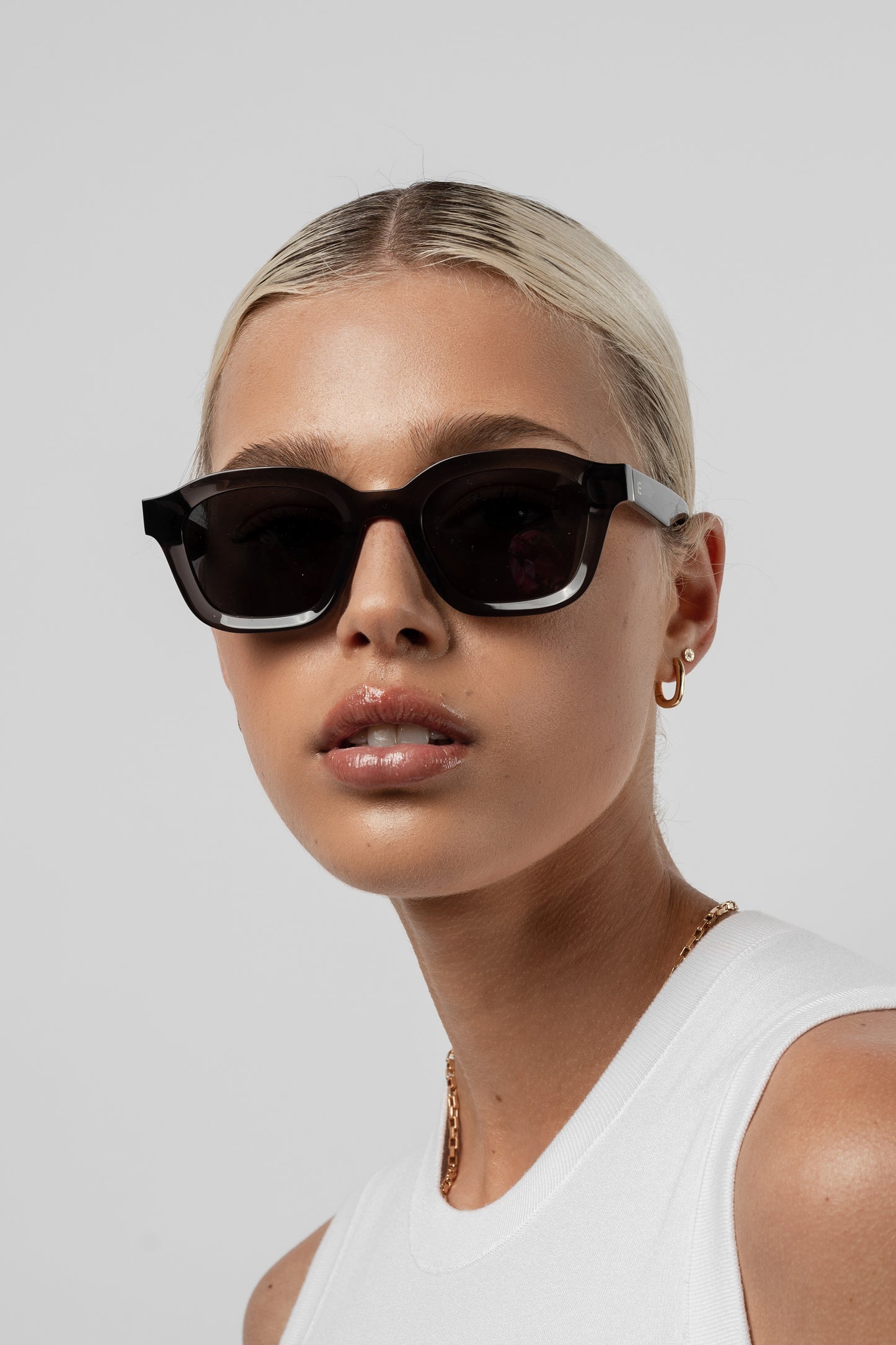 Female model wearing Isle of Eden Harley grey sunglasses, angled portrait