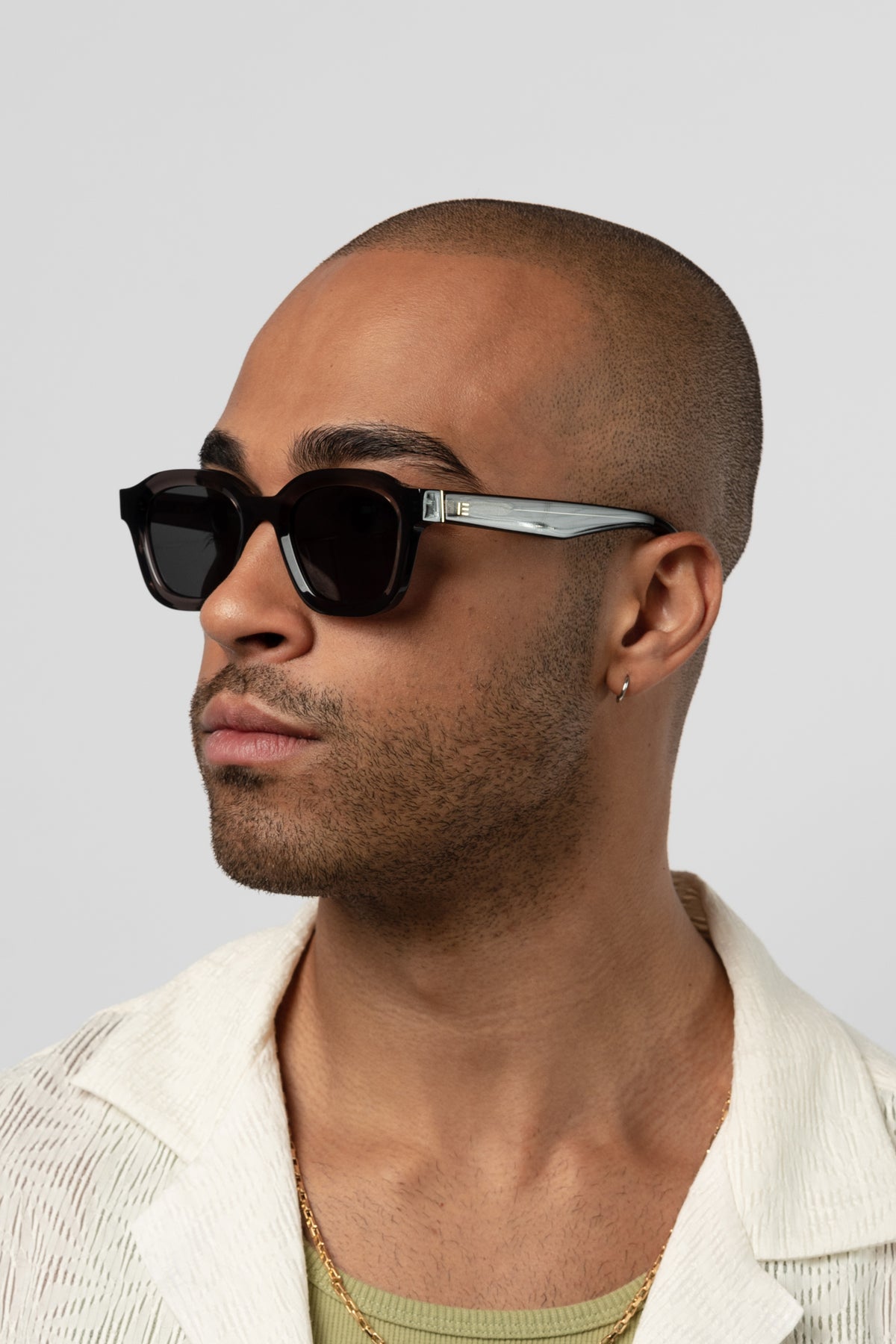 Male model wearing Isle of Eden Harley grey sunglasses, angled portrait