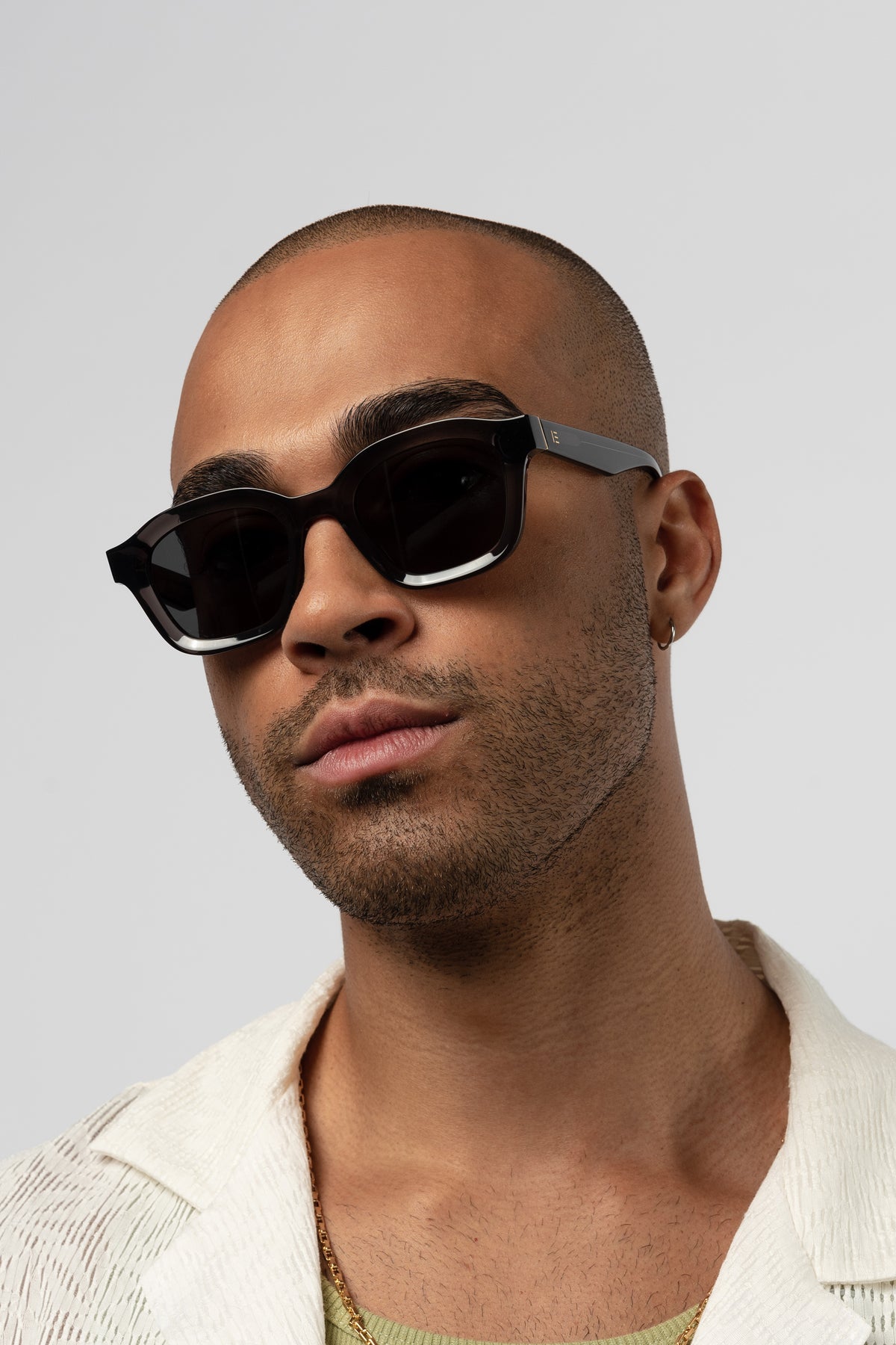 Male model wearing Isle of Eden Harley grey sunglasses, front-facing portrait looking directly at the camera