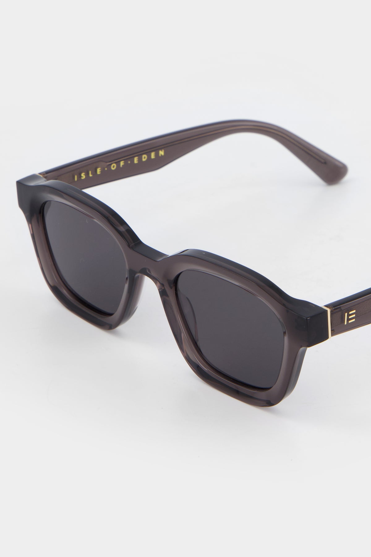 Close-up of Isle of Eden Harley grey sunglasses showing bold frame and brand lettering