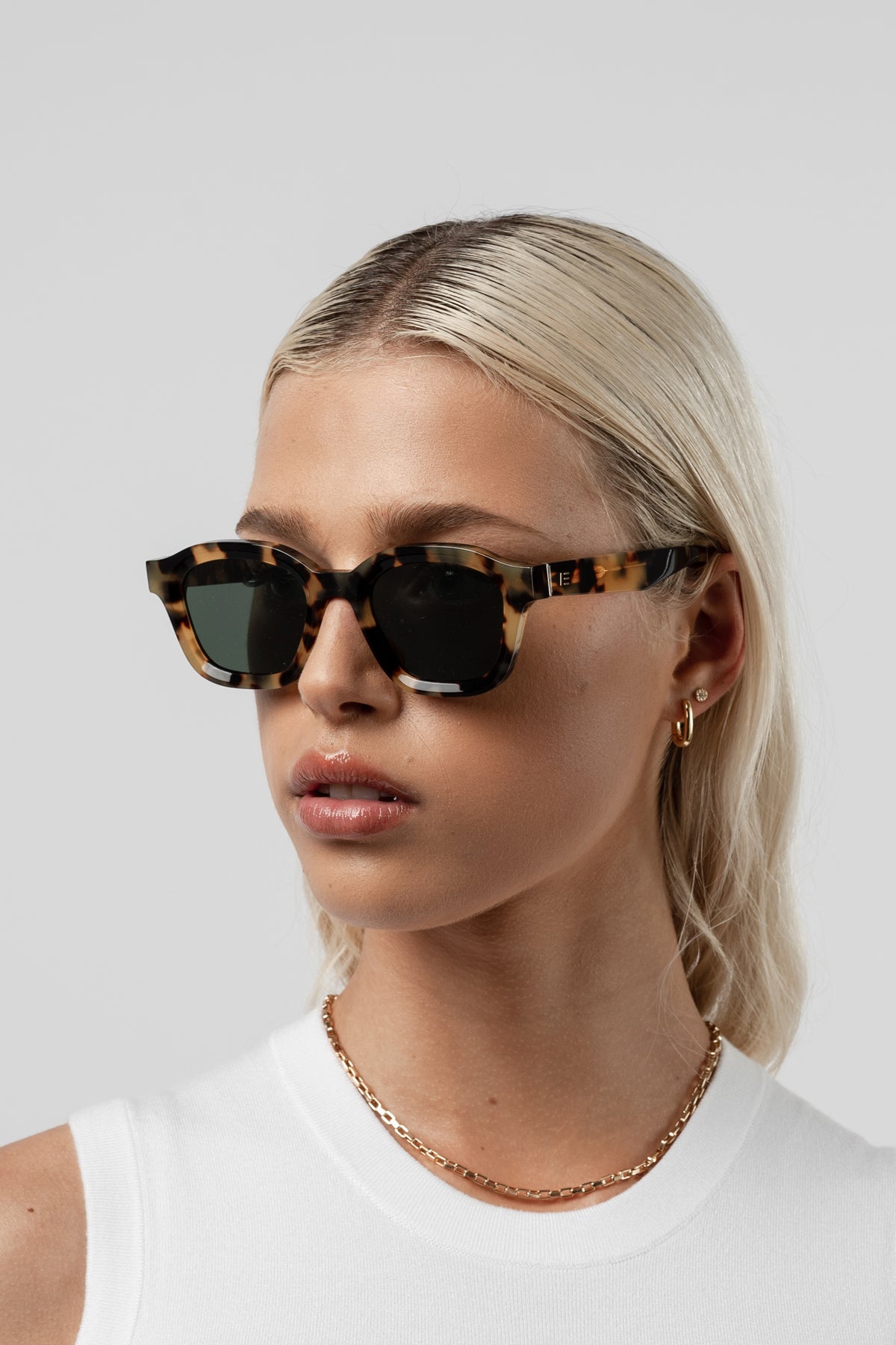 Female model wearing Isle of Eden Harley tortoise sunglasses, angled portrait looking away
