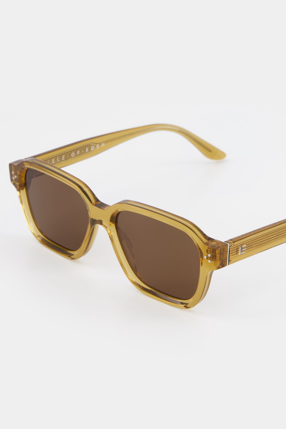 Close-up of Isle of Eden Jamie cognac sunglasses showing geometric frame and brand lettering