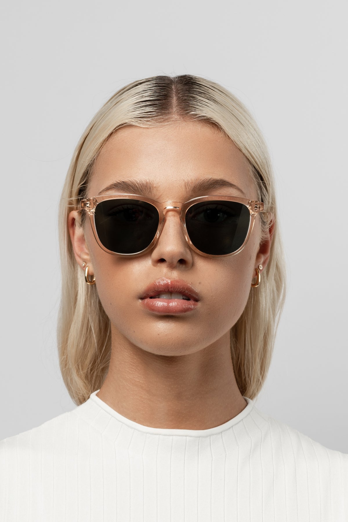 Woman wearing Isle of Eden Louis-Philippe champagne sunglasses, front-facing portrait against a light background