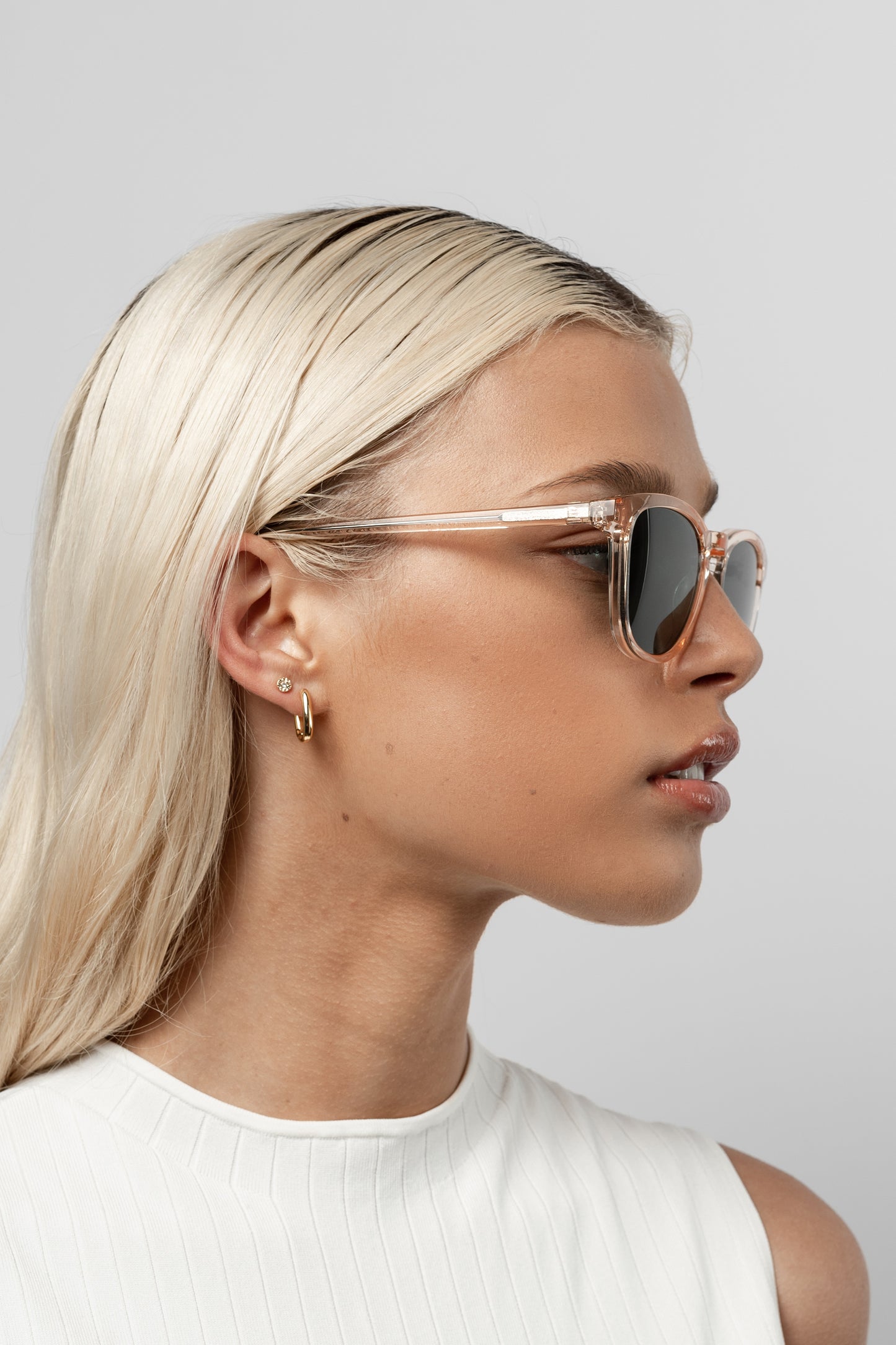 Woman wearing Isle of Eden Louis-Philippe champagne sunglasses, side profile portrait against a light background