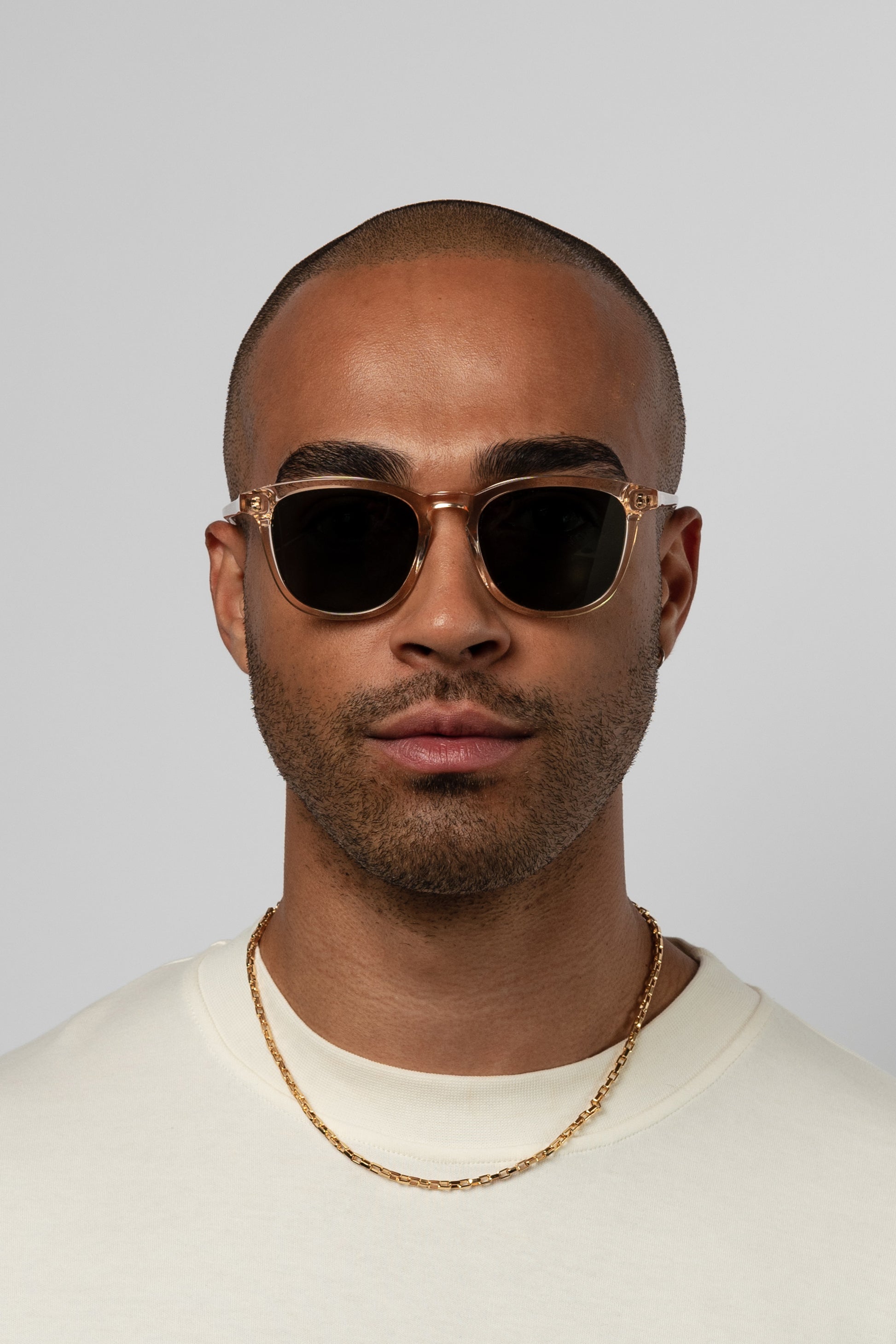 Man wearing Isle of Eden Louis-Philippe champagne sunglasses, front-facing portrait against a light background
