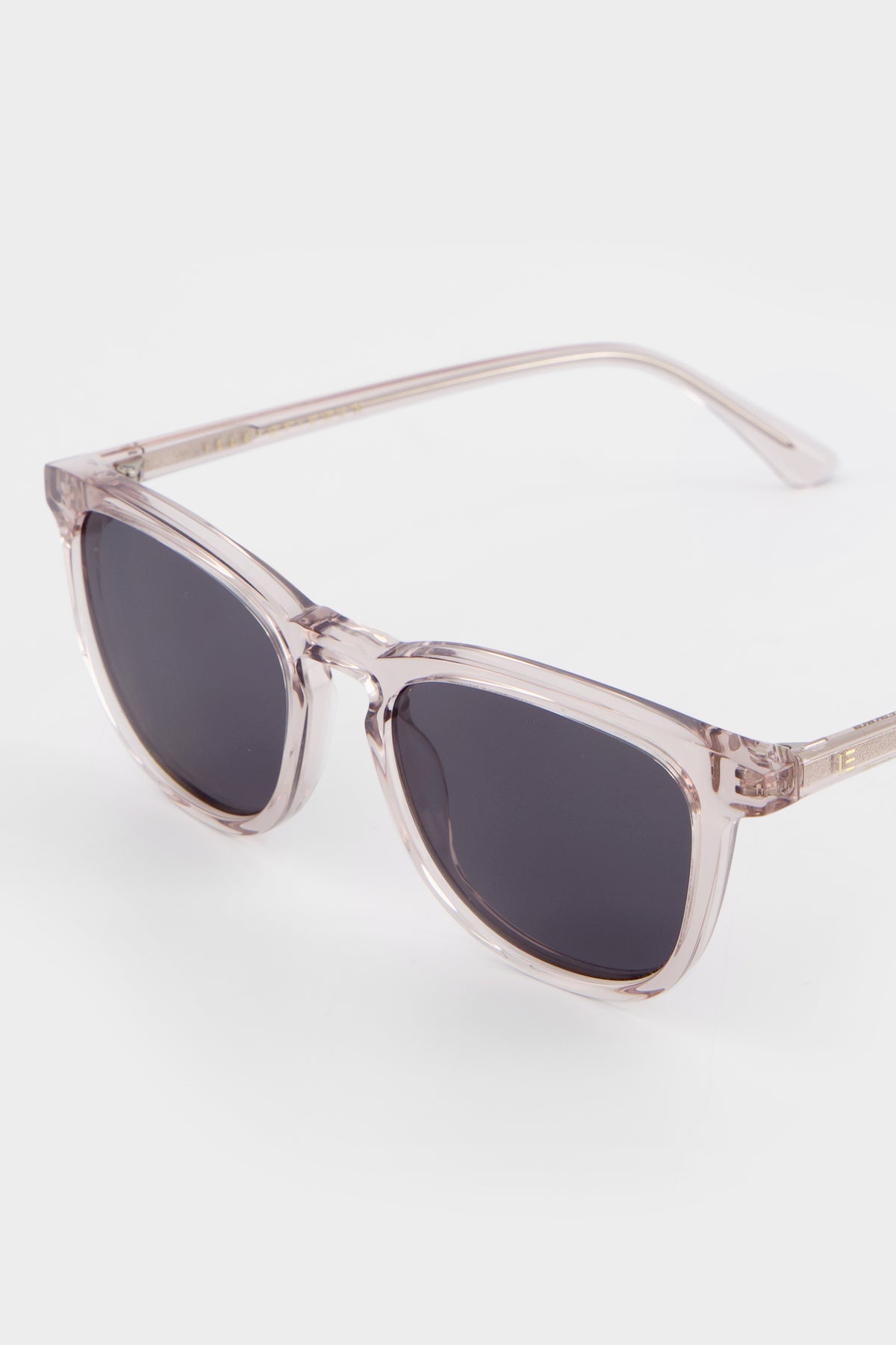 Close-up of Isle of Eden Louis-Philippe sand sunglasses temple showing hinge detail and translucent acetate texture