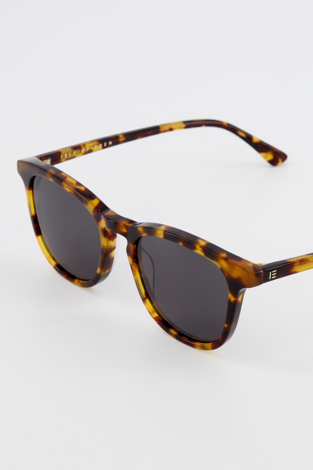 Close-up of Isle of Eden Louis-Philippe tortoiseshell sunglasses temple showing hinge detail and brand lettering