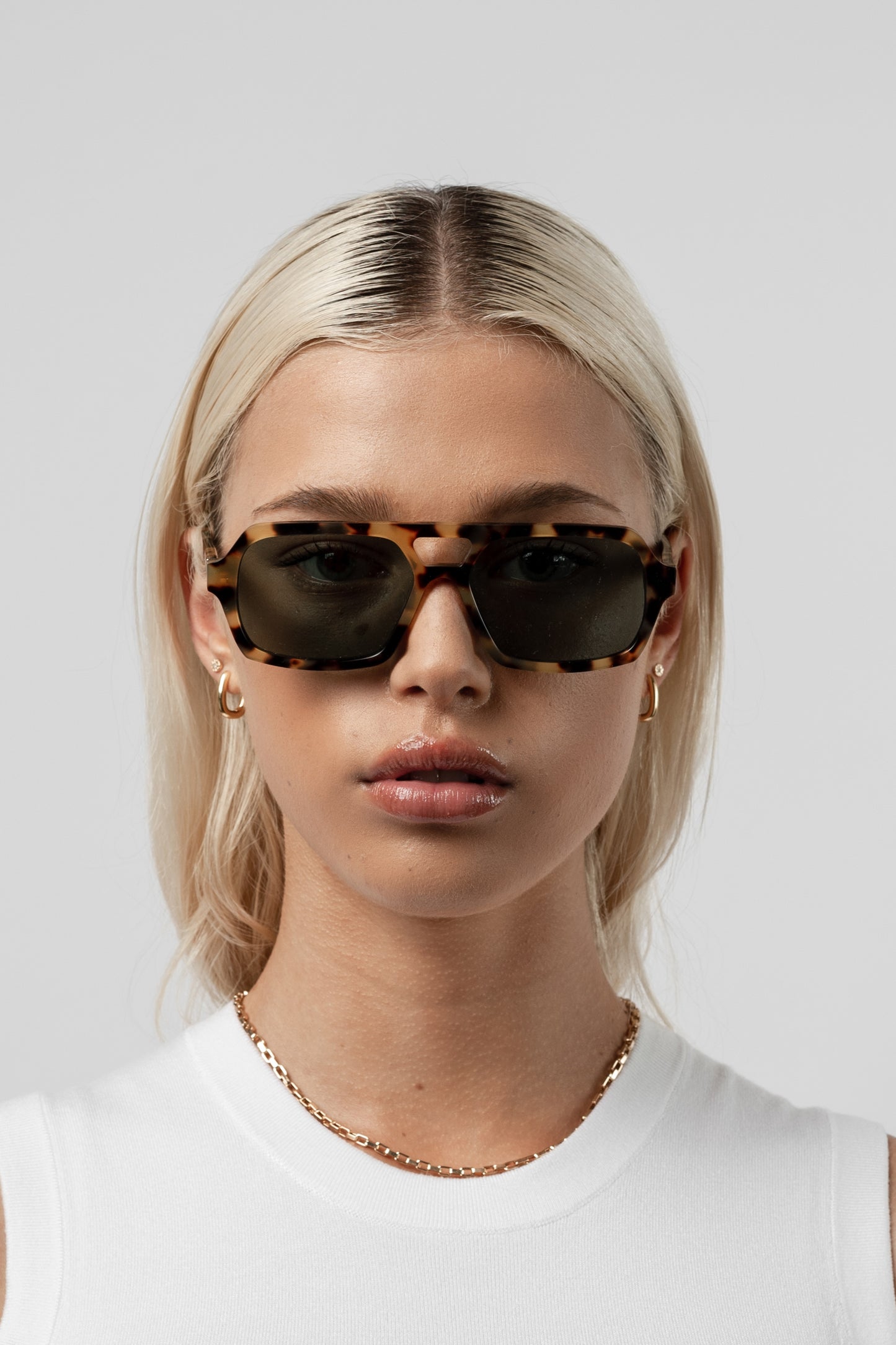 Female model wearing Isle of Eden Lola tortoise sunglasses, close front-facing portrait looking directly at the camera