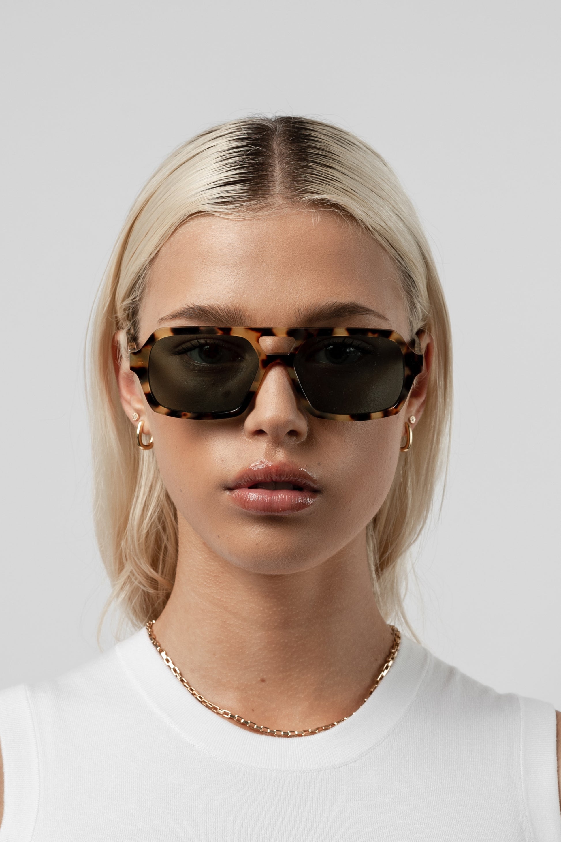 Female model wearing Isle of Eden Lola tortoise sunglasses, close front-facing portrait looking directly at the camera