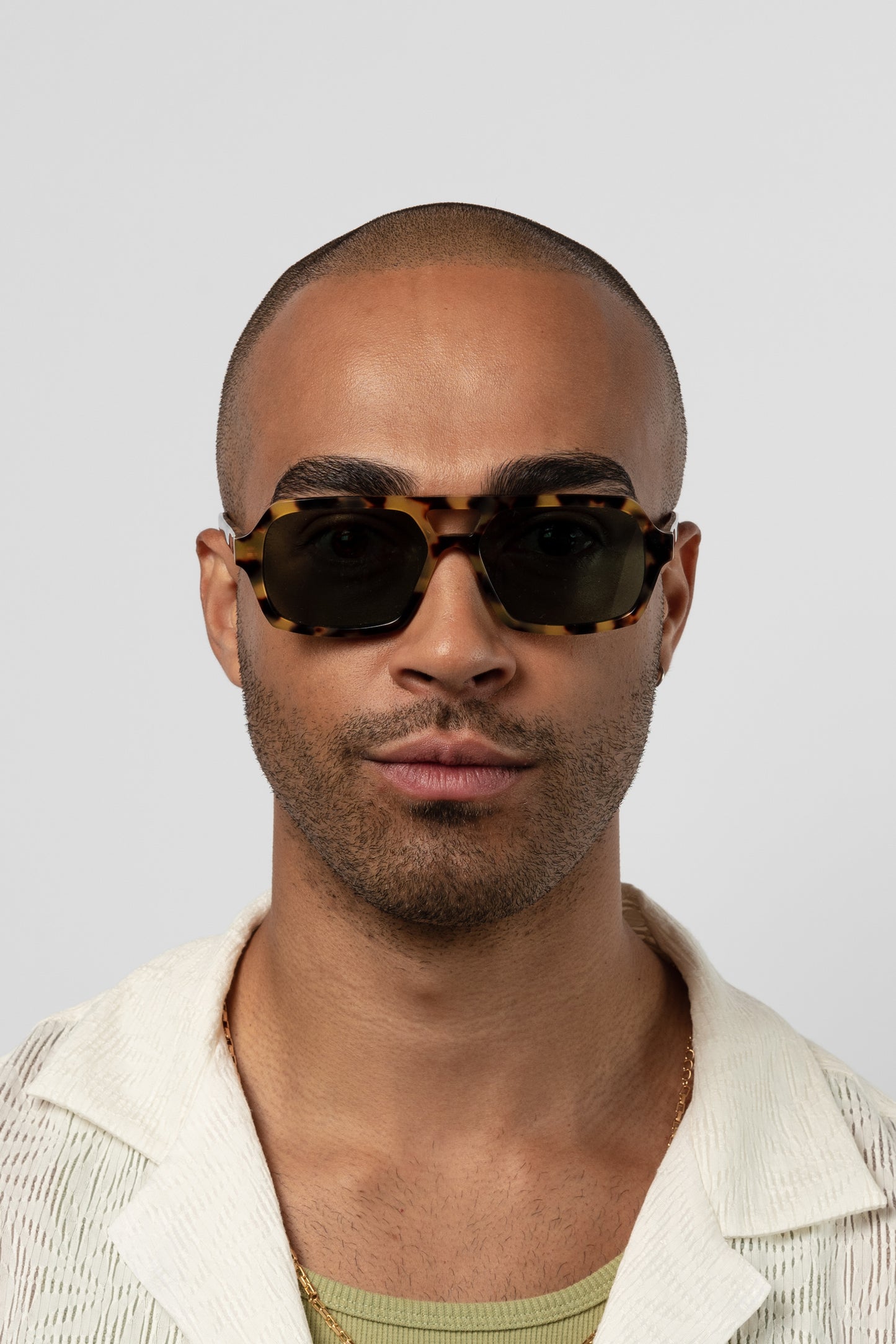 Male model wearing Isle of Eden Lola tortoise sunglasses, front-facing portrait looking directly at the camera