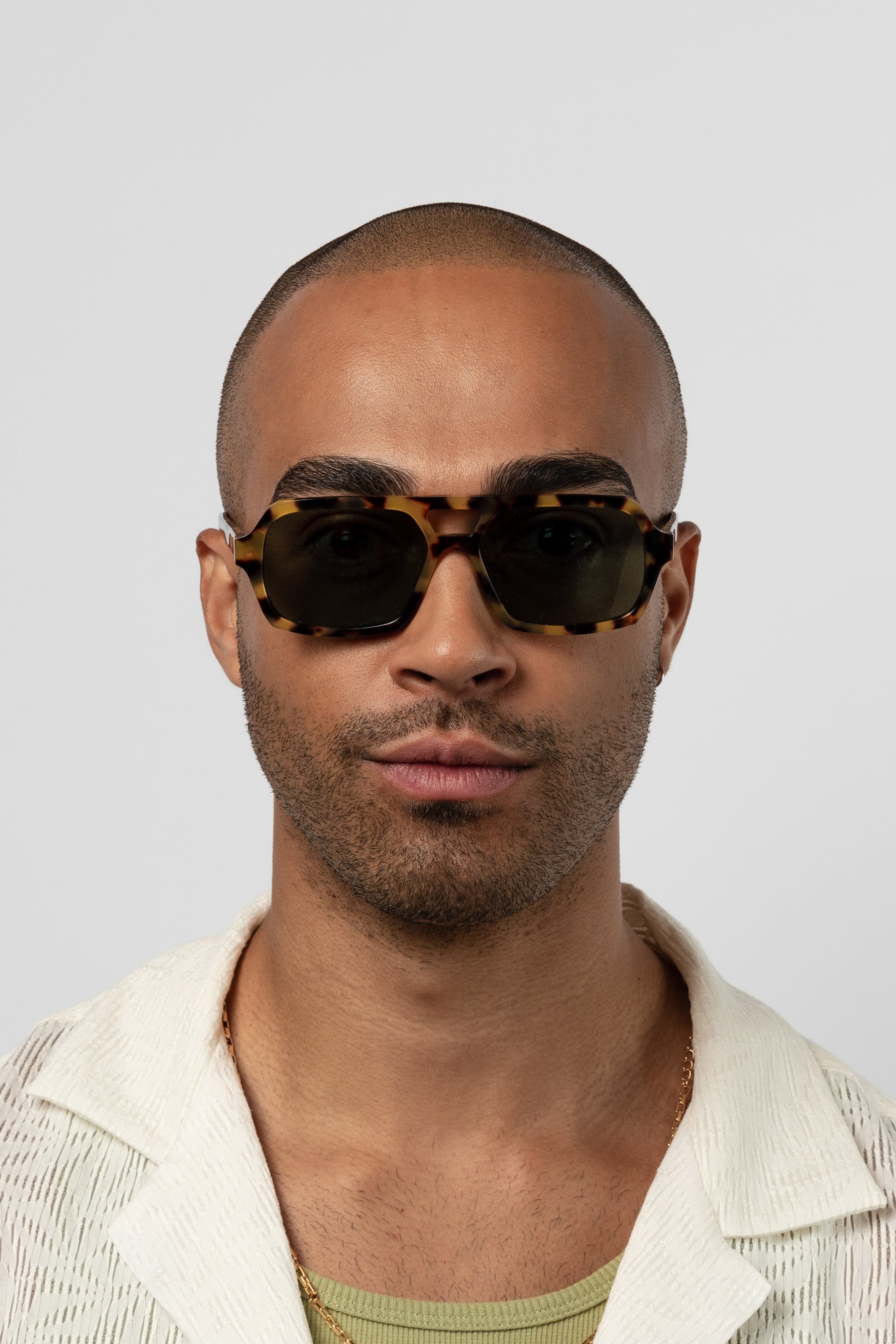Male model wearing Isle of Eden Lola tortoise sunglasses, front-facing portrait looking directly at the camera