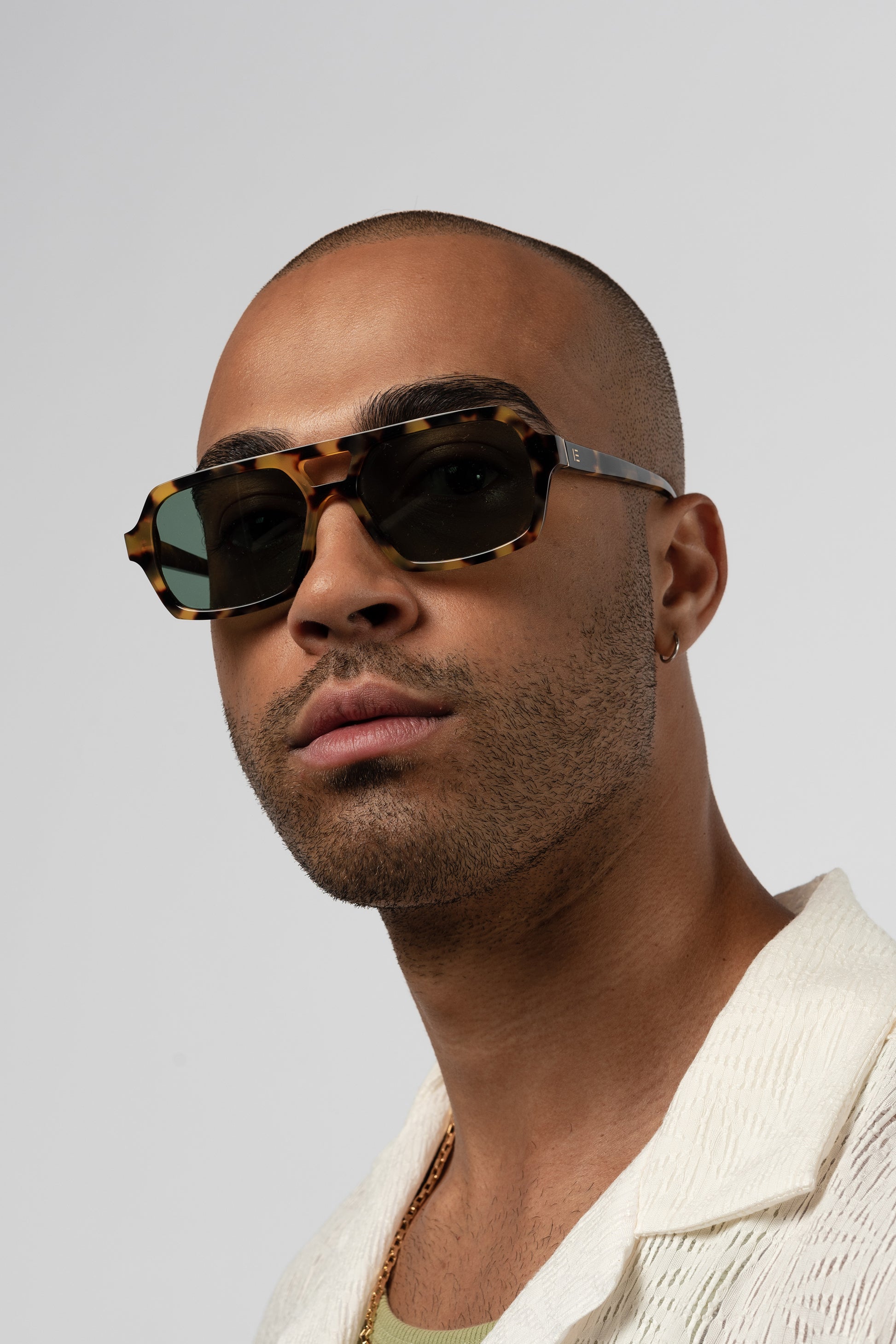 Male model wearing Isle of Eden Lola tortoise sunglasses, angled portrait looking away