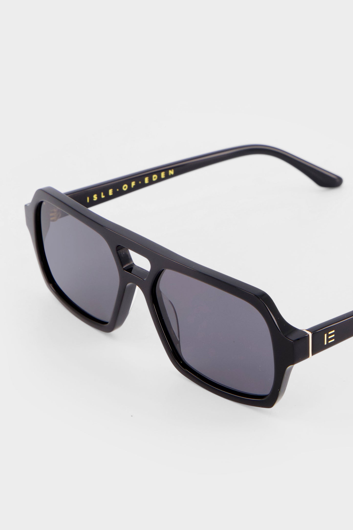Close-up of Isle of Eden Lola black sunglasses showing aviator frame and brand lettering